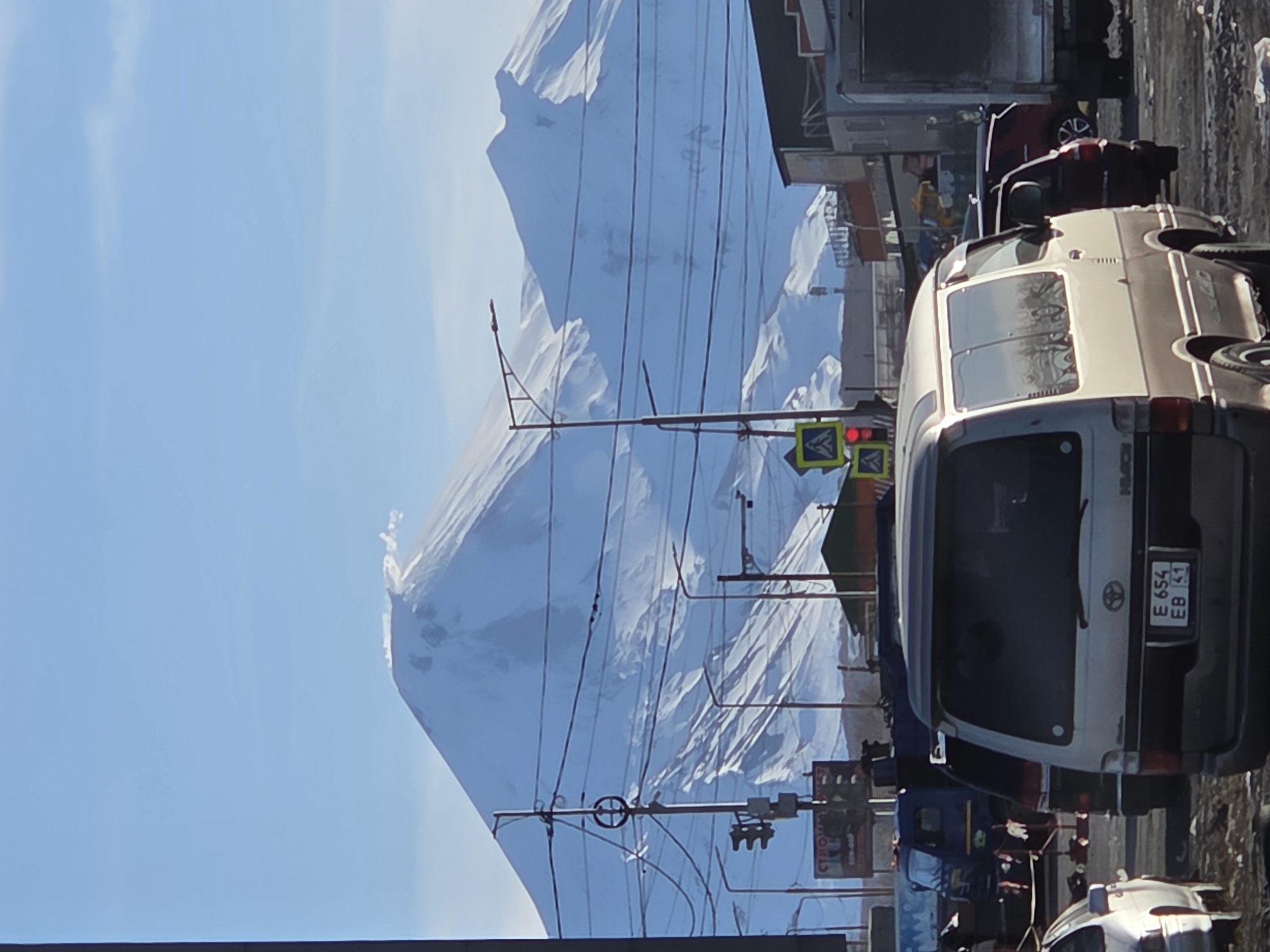 Snow-capped mountain visible from city streets during evening hours