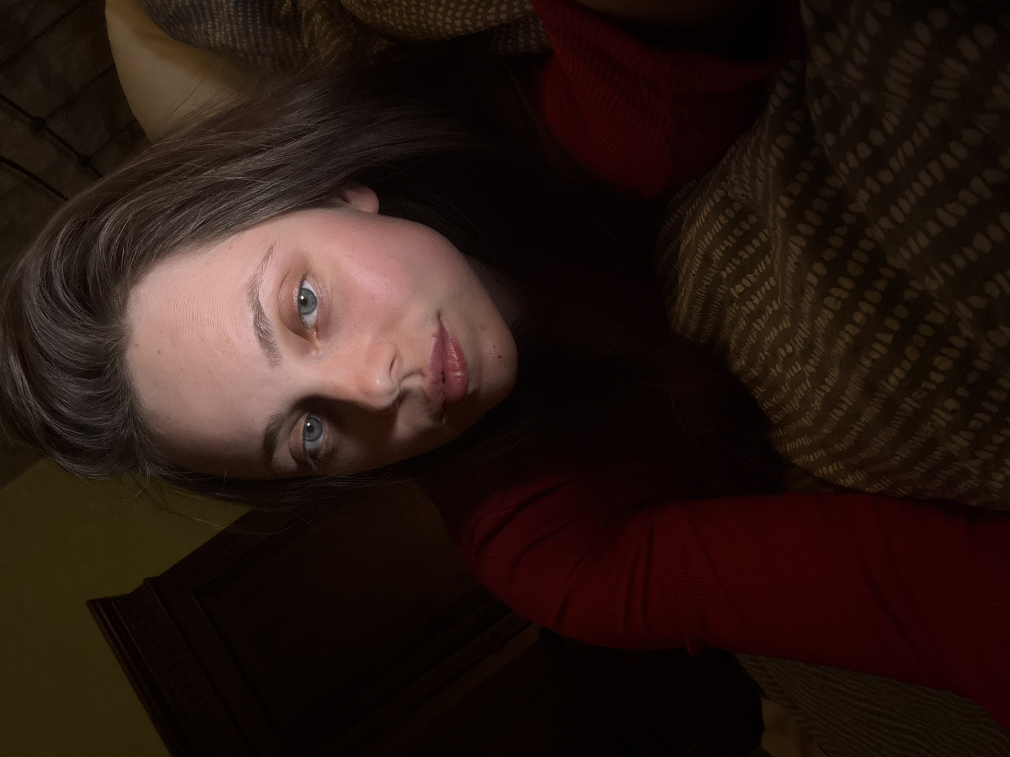 Woman in red shirt resting indoors in Budapest