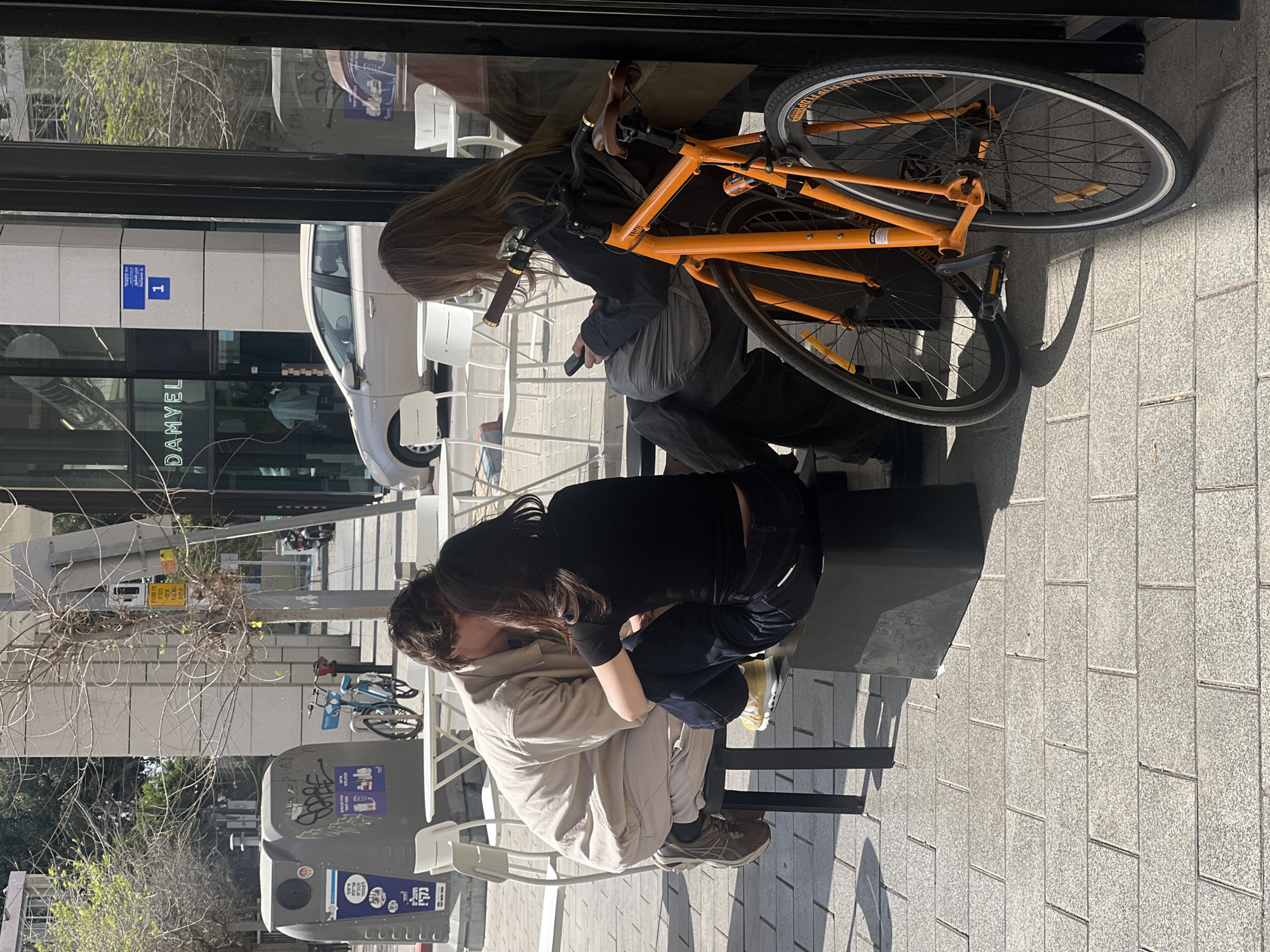 Woman takes mirror selfie with orange iPhone in Tel Aviv