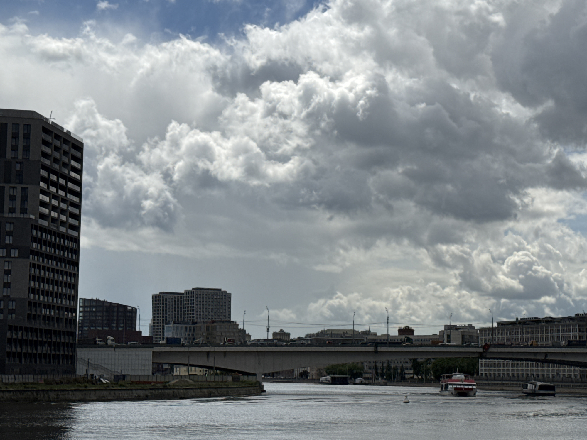 Moscow scenes: dramatic clouds over river, man in graphic tee