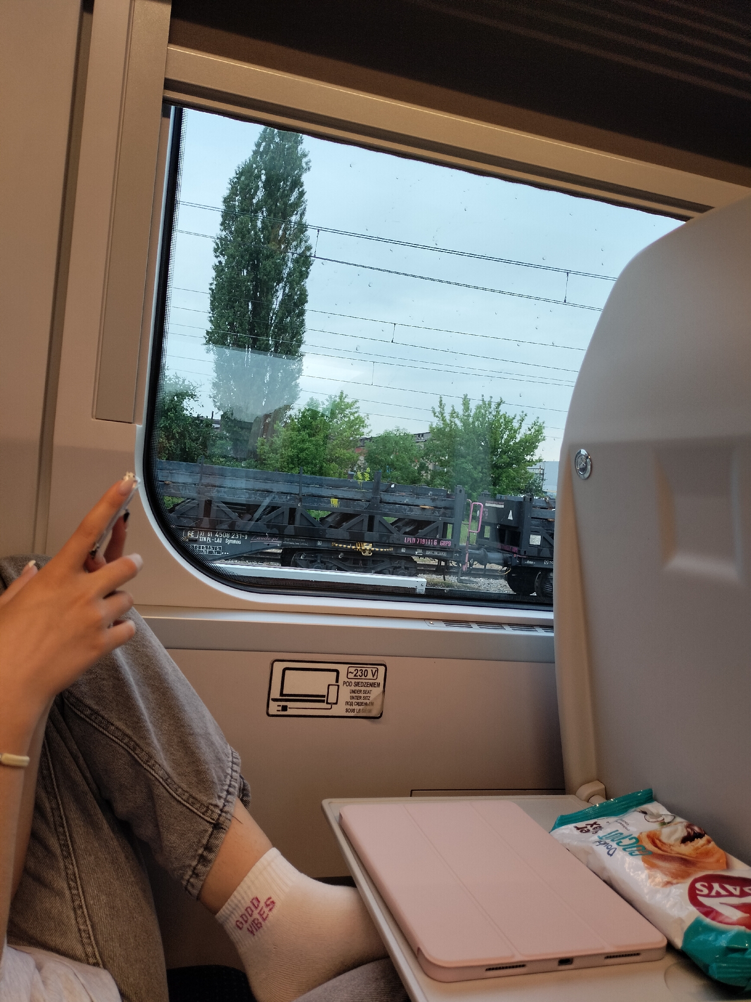 Solo train passenger documents rural countryside journey at sunset