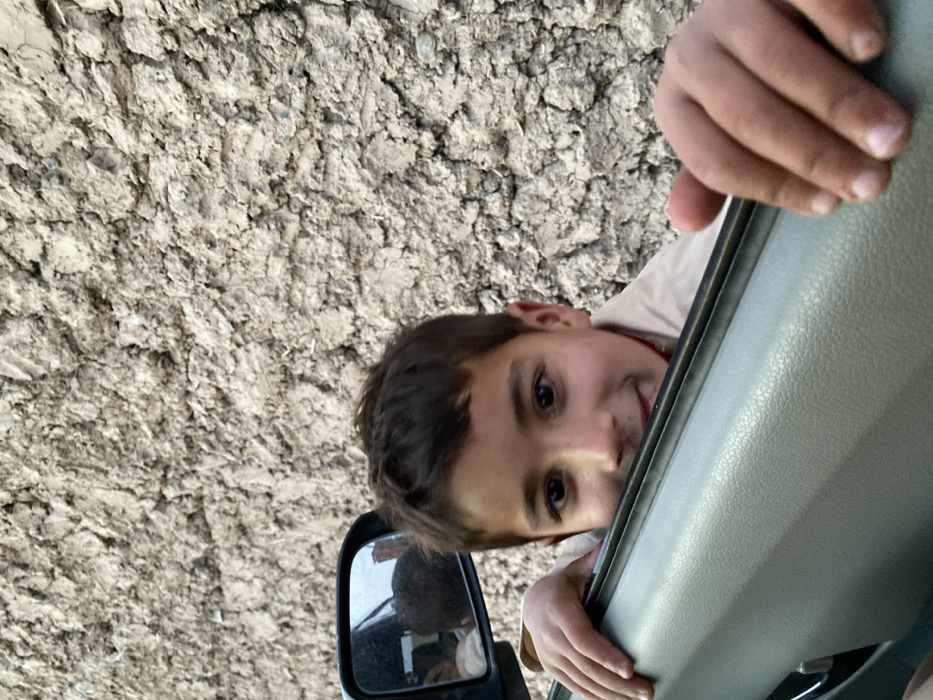 Young boy interacts with vehicle occupants in Kandahar