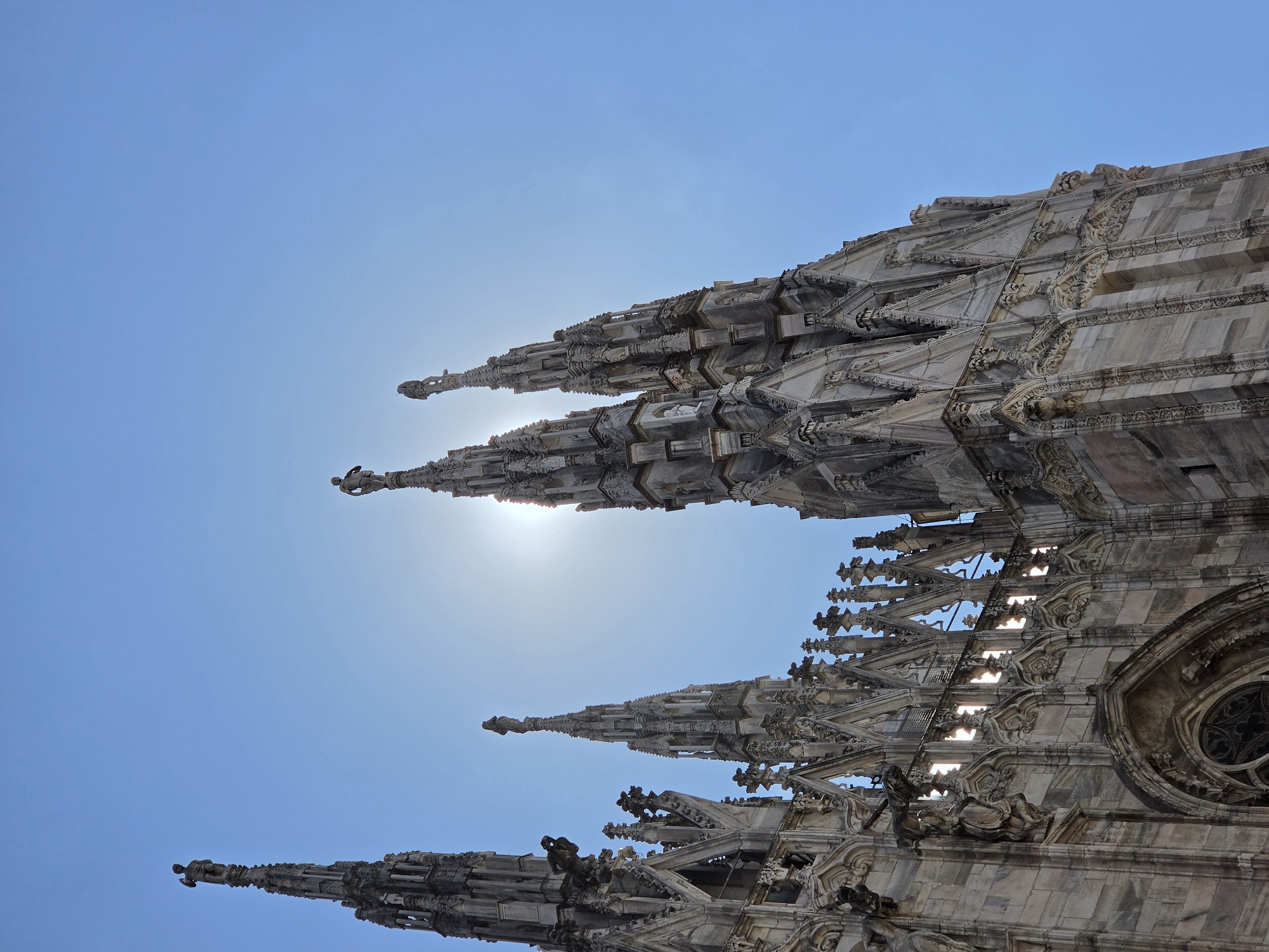 Gothic spires and street-level Milan on a bright afternoon