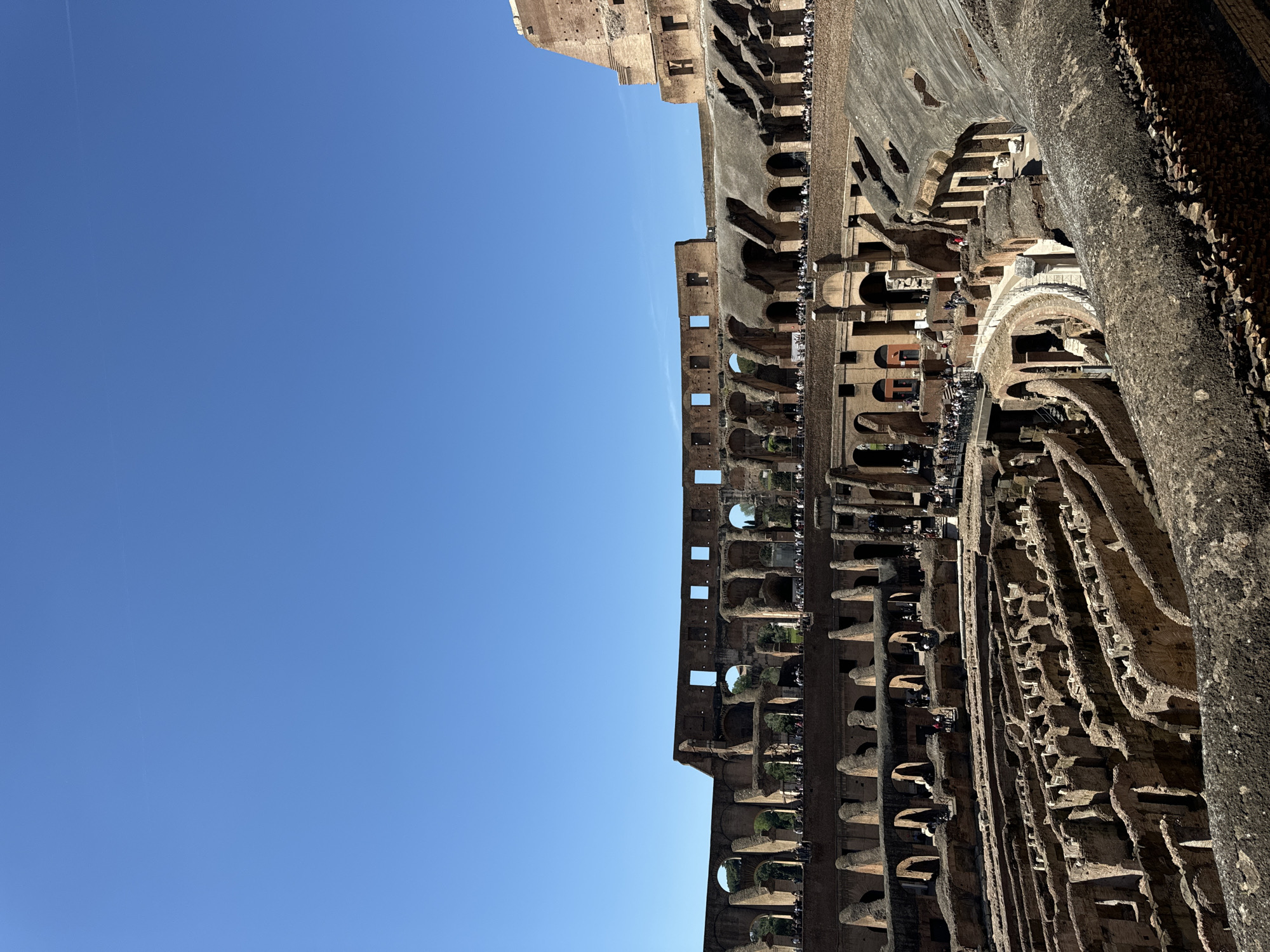 Tourists explore Colosseum ruins on sunny Sunday morning