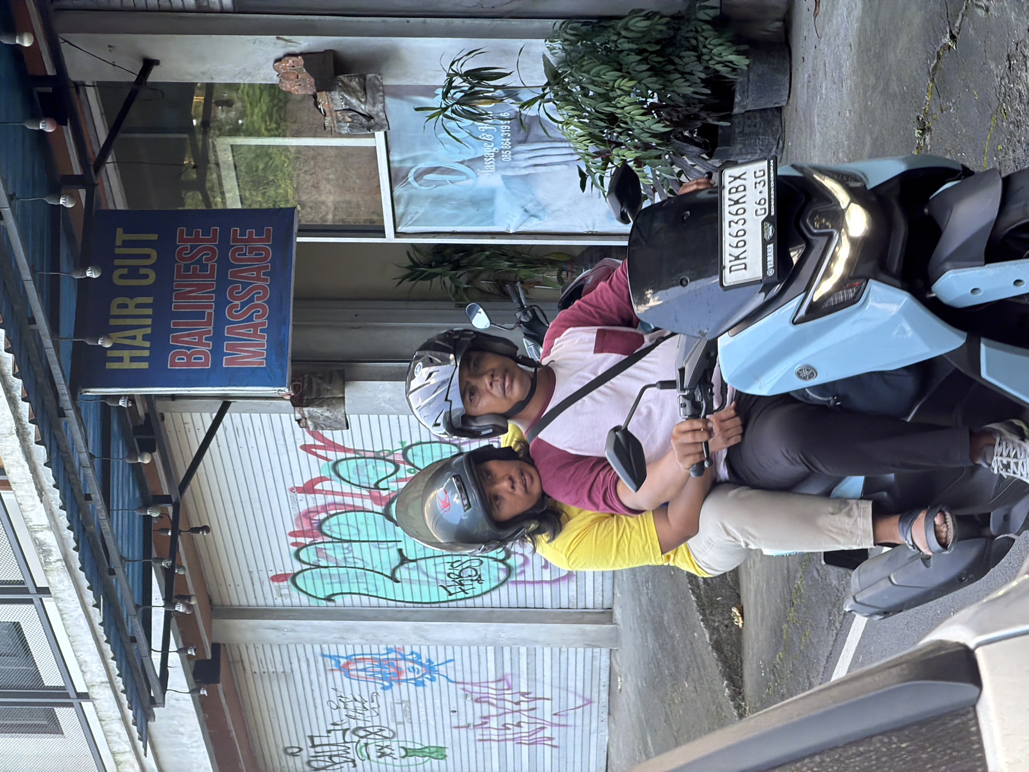 Street life and storefronts along a busy Ubud road