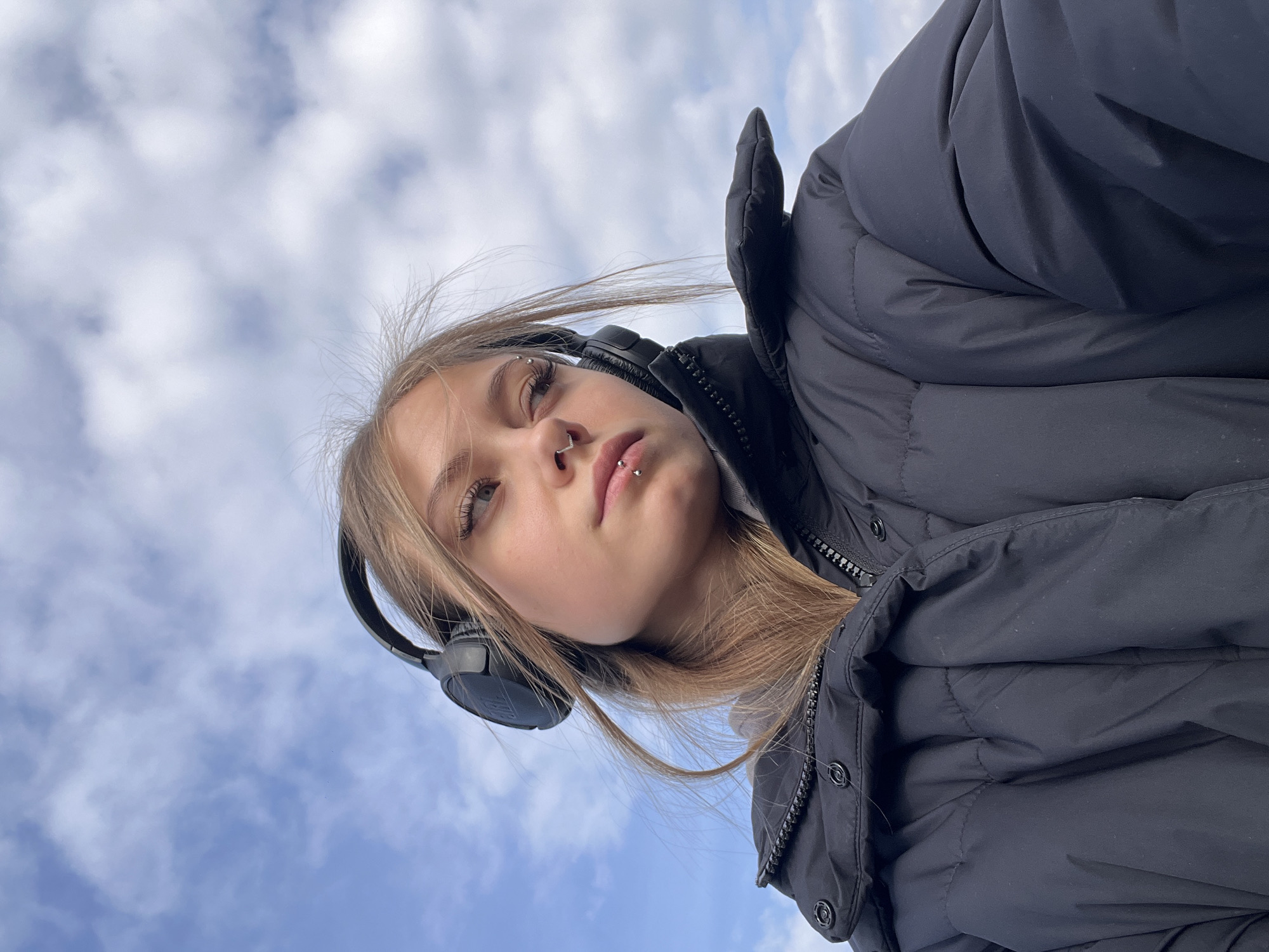 Woman in headphones stands in snowy field, Фоки Russia