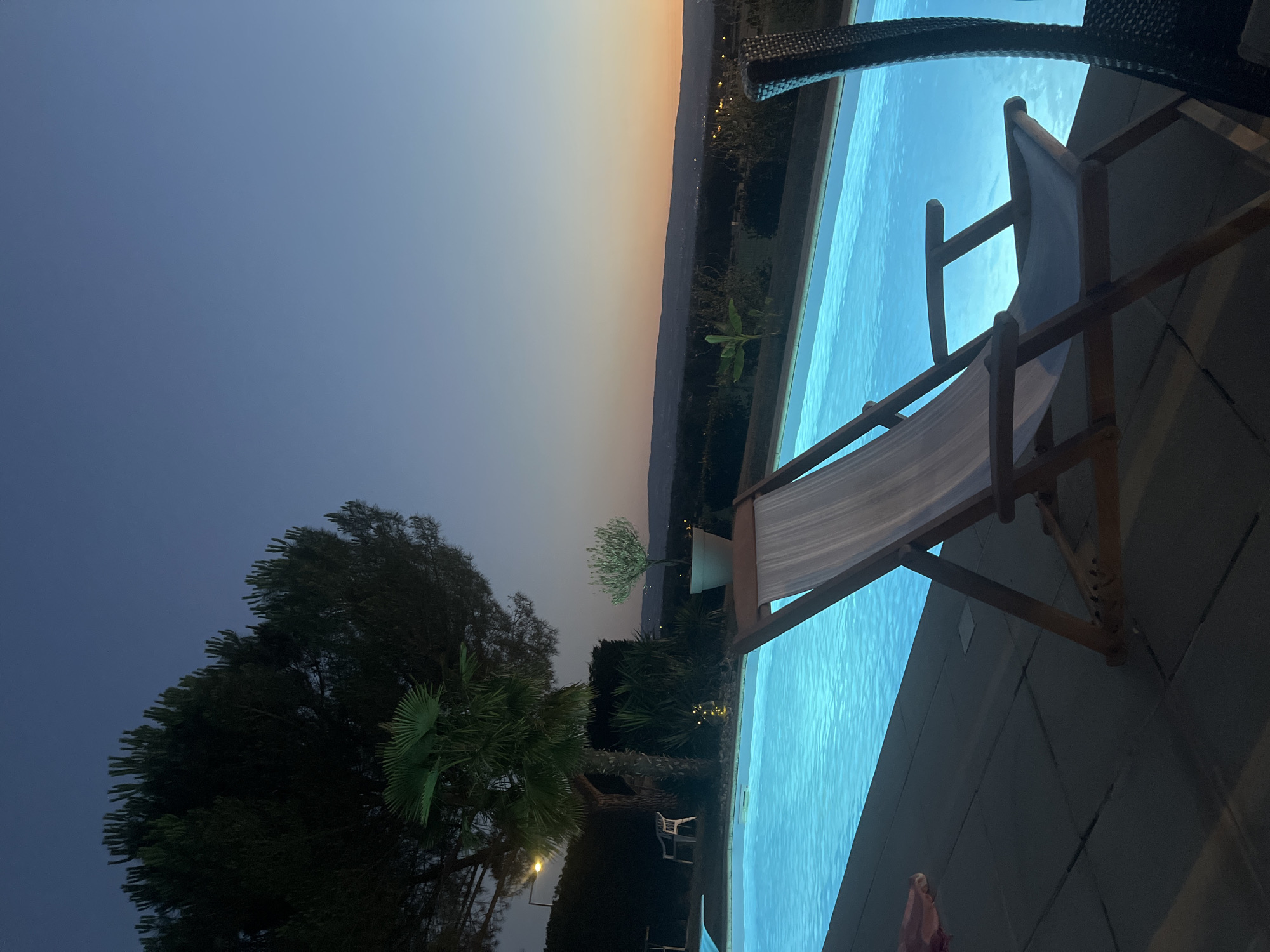 Evening poolside relaxation at a lit outdoor pool in Saint-Galmier