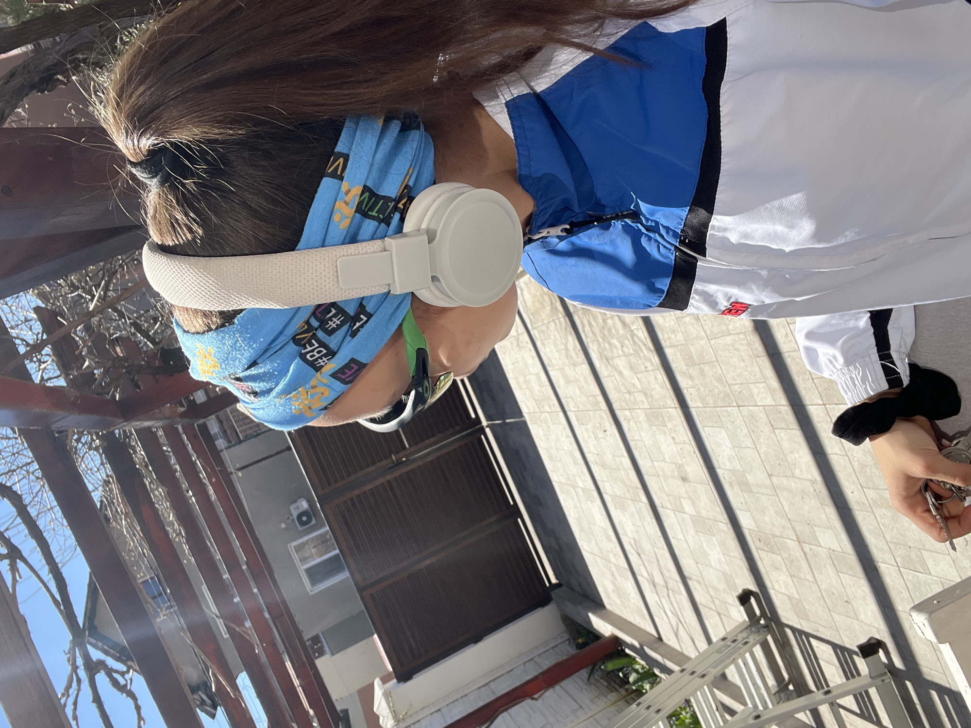 Person with headphones holds keys outside Pernik building