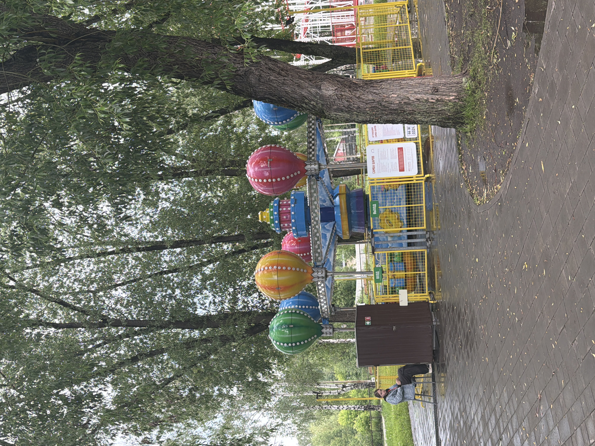 Amusement park visitors enjoy rides on cloudy afternoon