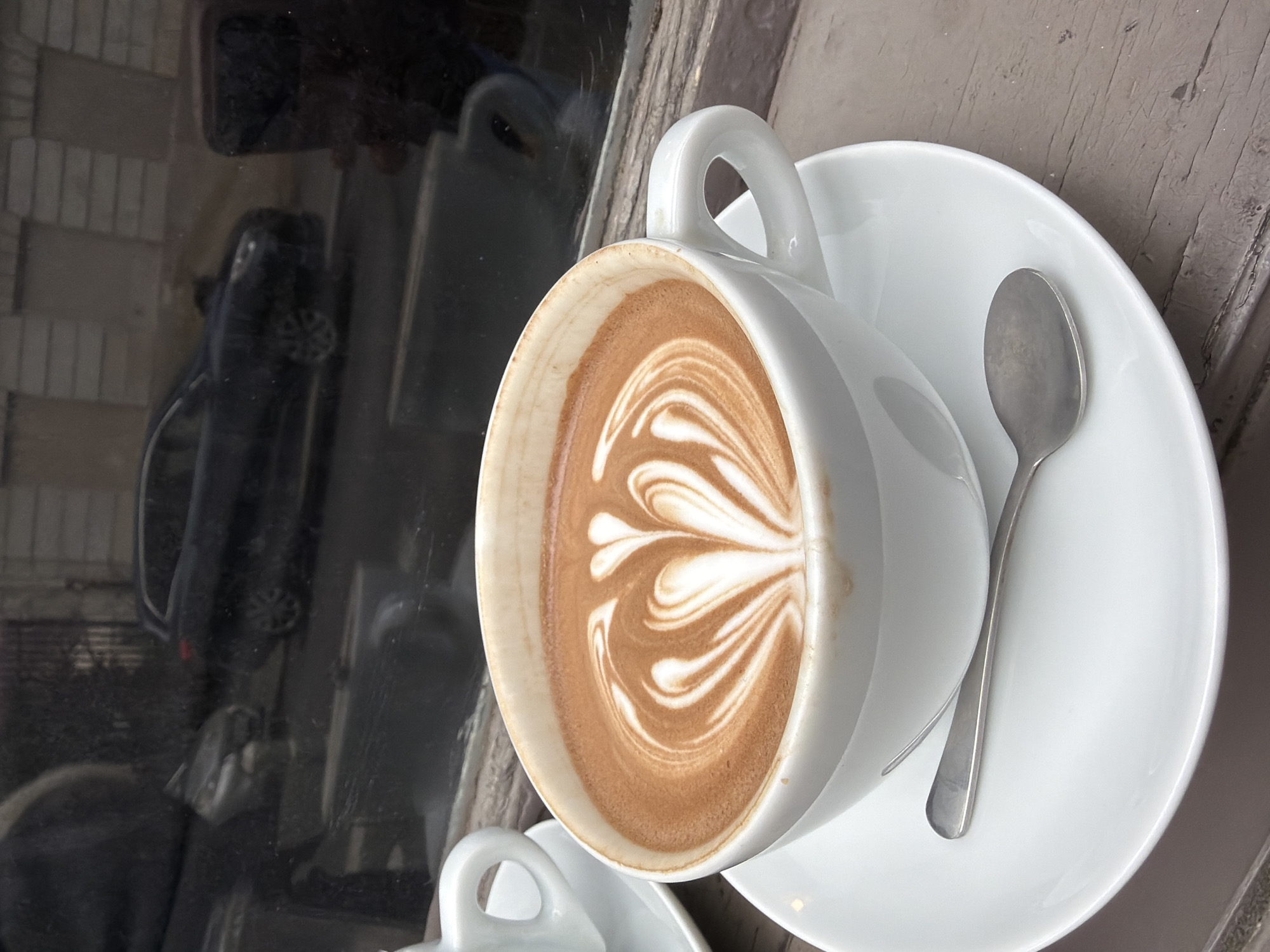 Coffee moment captured at Paris café with artistic latte