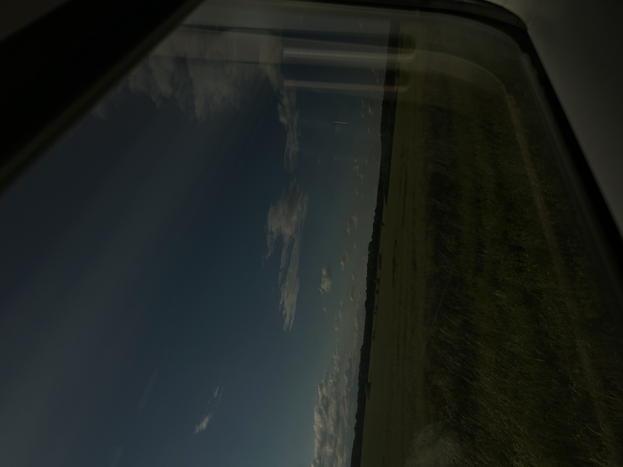 Train passenger documents rural German countryside during evening journey