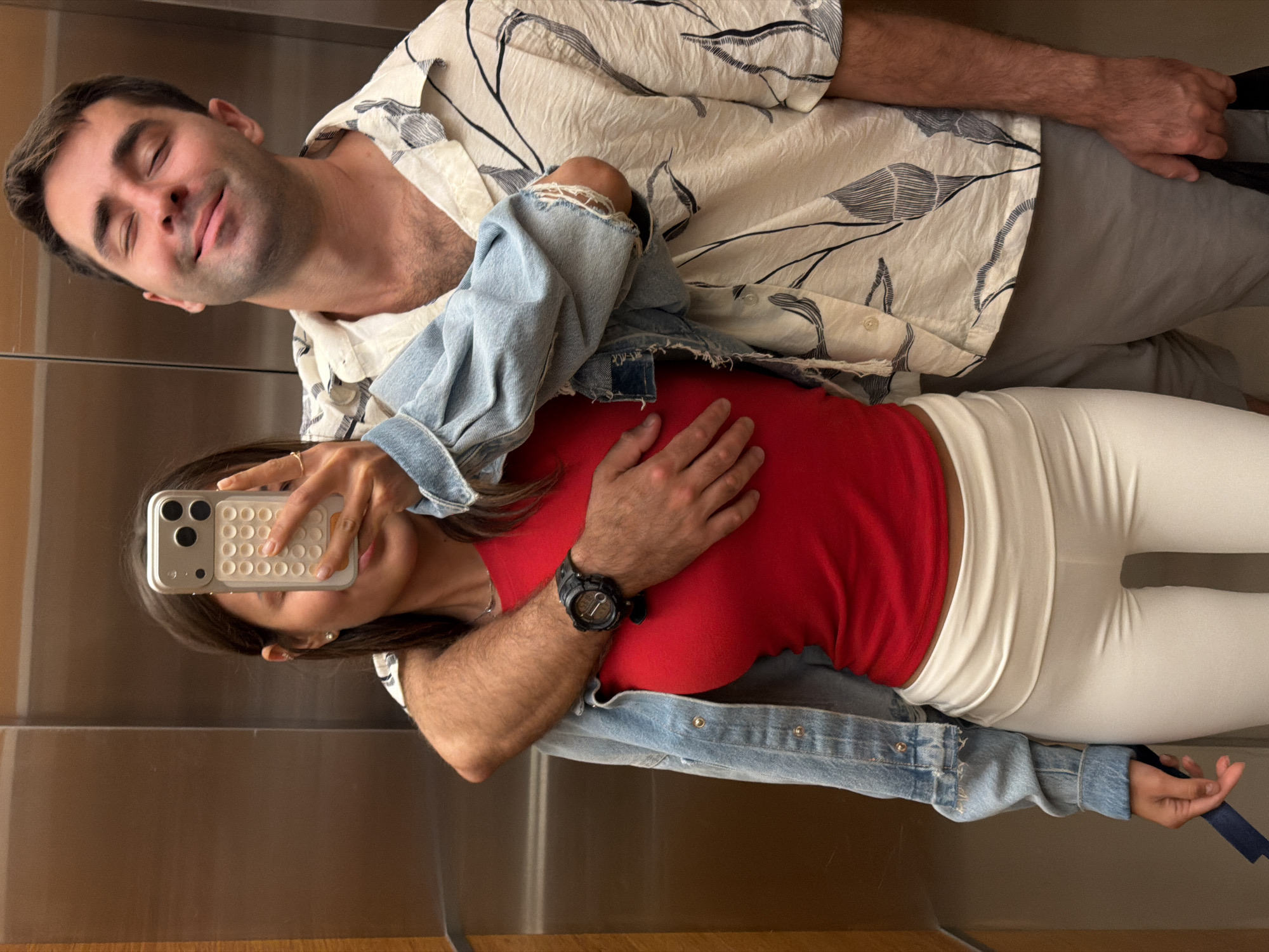 Elevator mirror selfie with a cheek kiss, Tel Aviv
