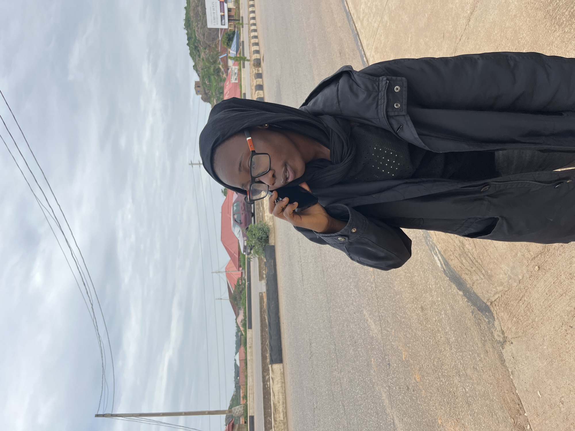 Afternoon street scene in Gura Top, Nigeria with cake and a phone call