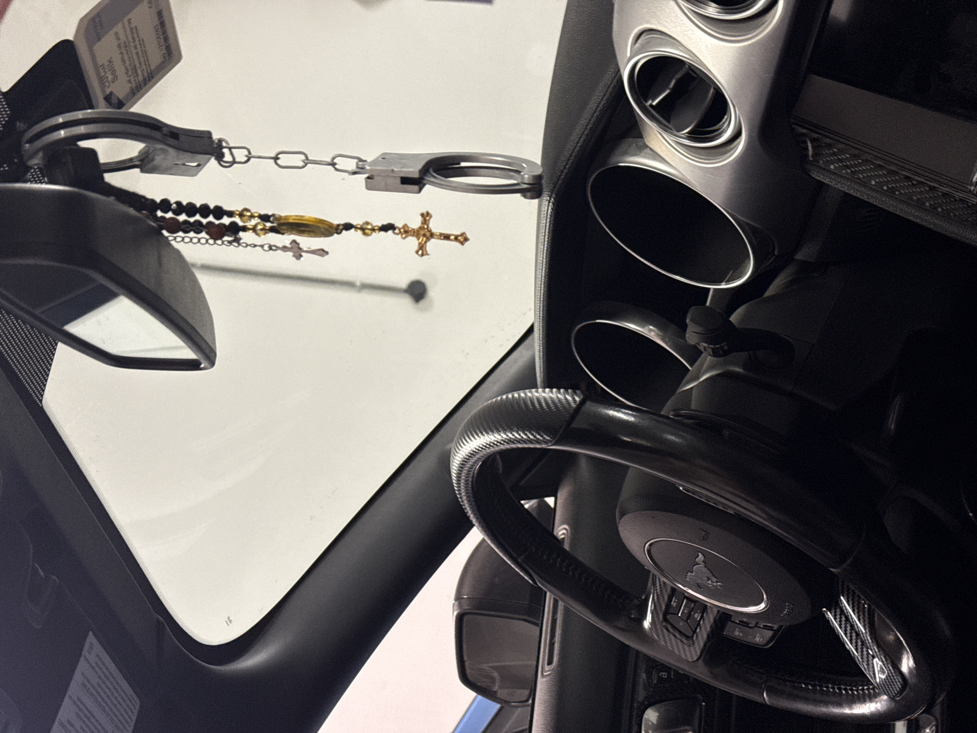 Vehicle interior with handcuffs, cross necklace photographed in Dubai
