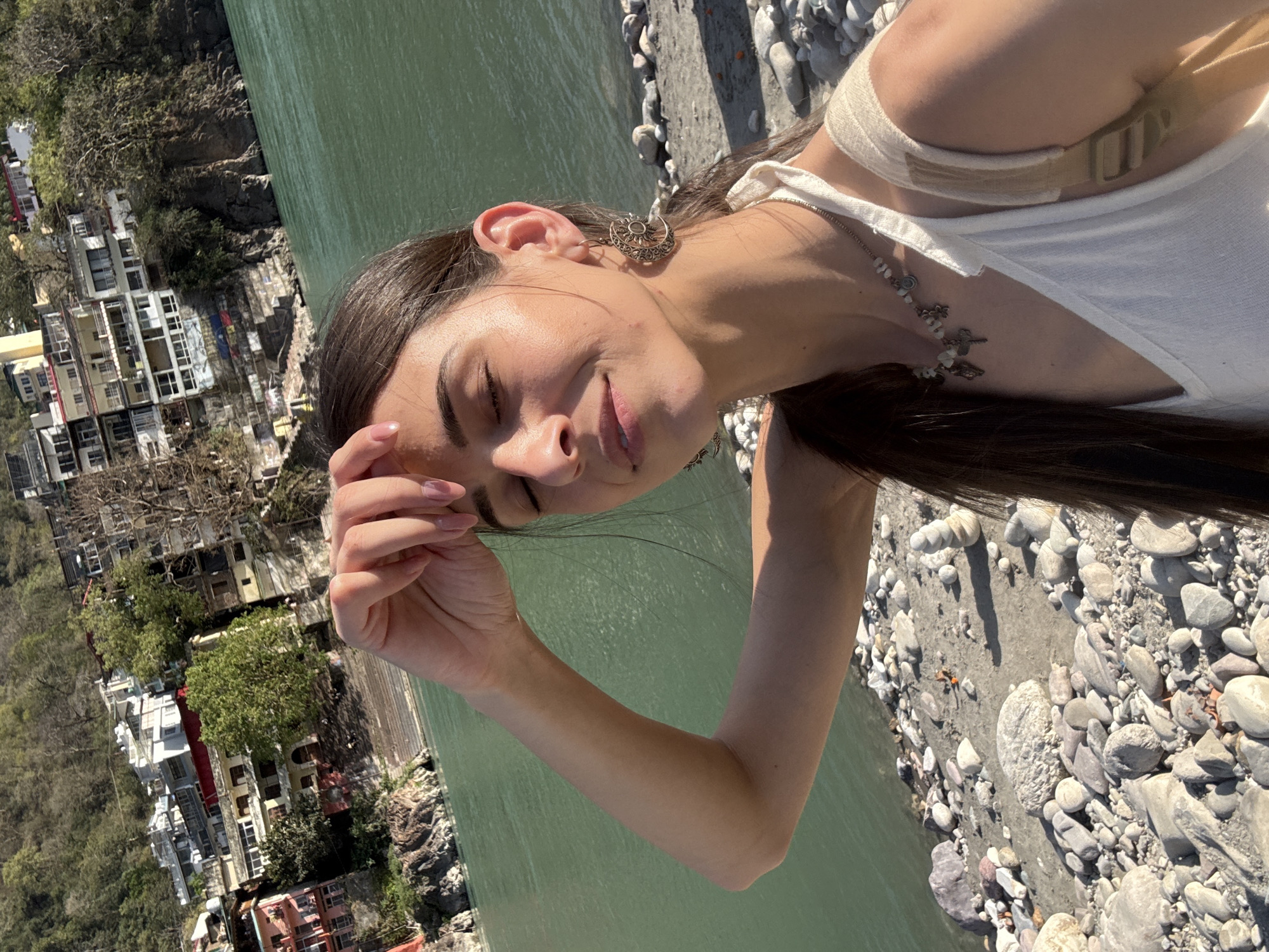 Woman enjoys peaceful moment along Ganges River in Rishikesh