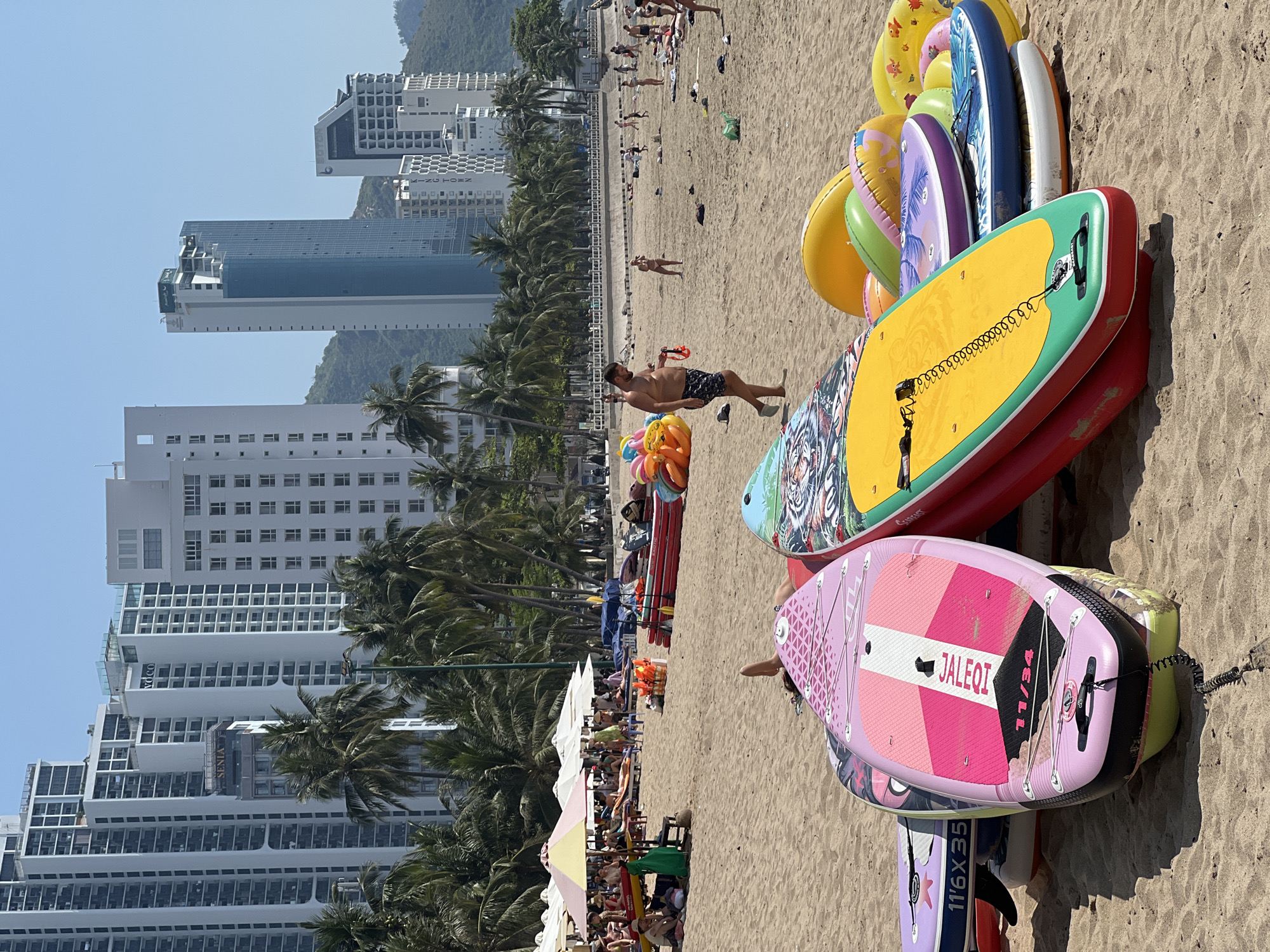 Nha Trang beach day: swimmers, sun gear, and a golden retriever