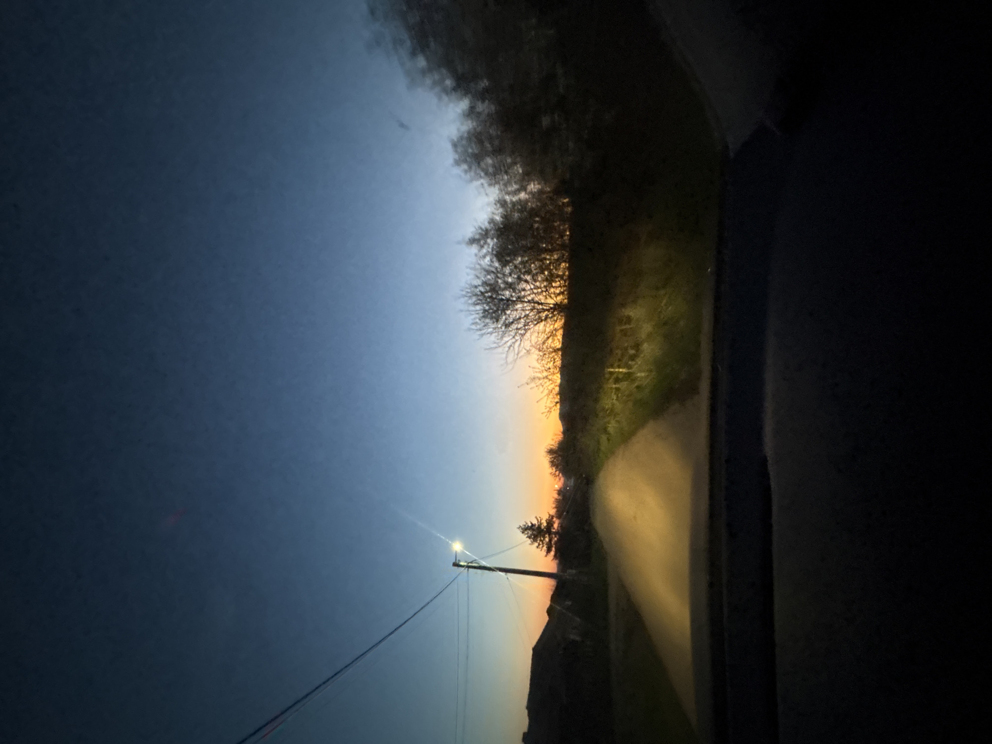 Vehicle passenger documents sunset to nighttime transition on rural road