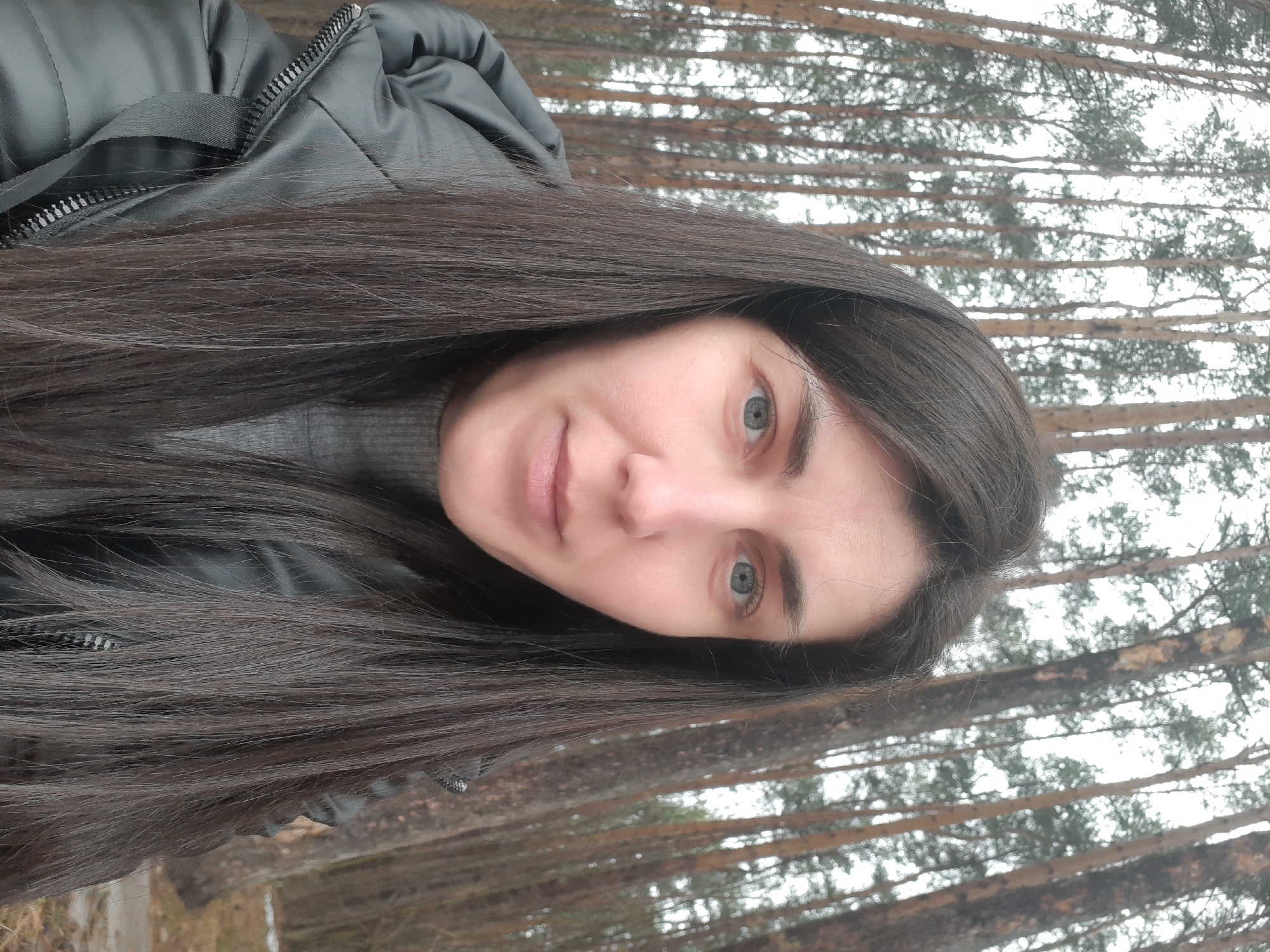 Woman photographed during forest walk among pine trees