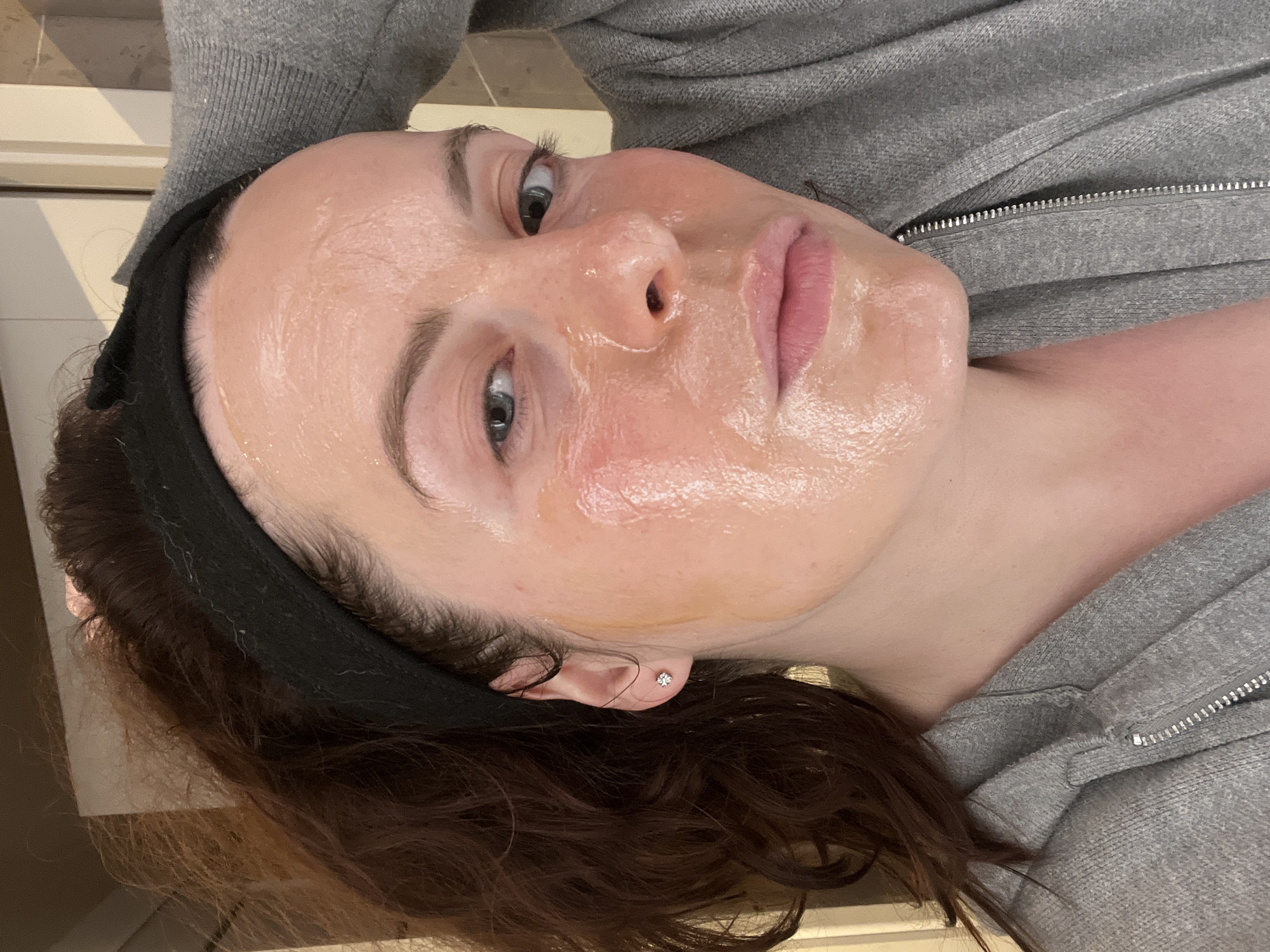 Woman applies skincare treatment during evening routine in Gangloff