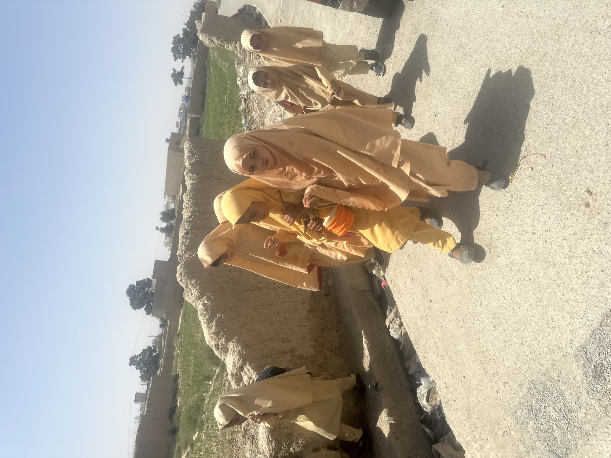 Single-file walk along a dusty path in Quetta