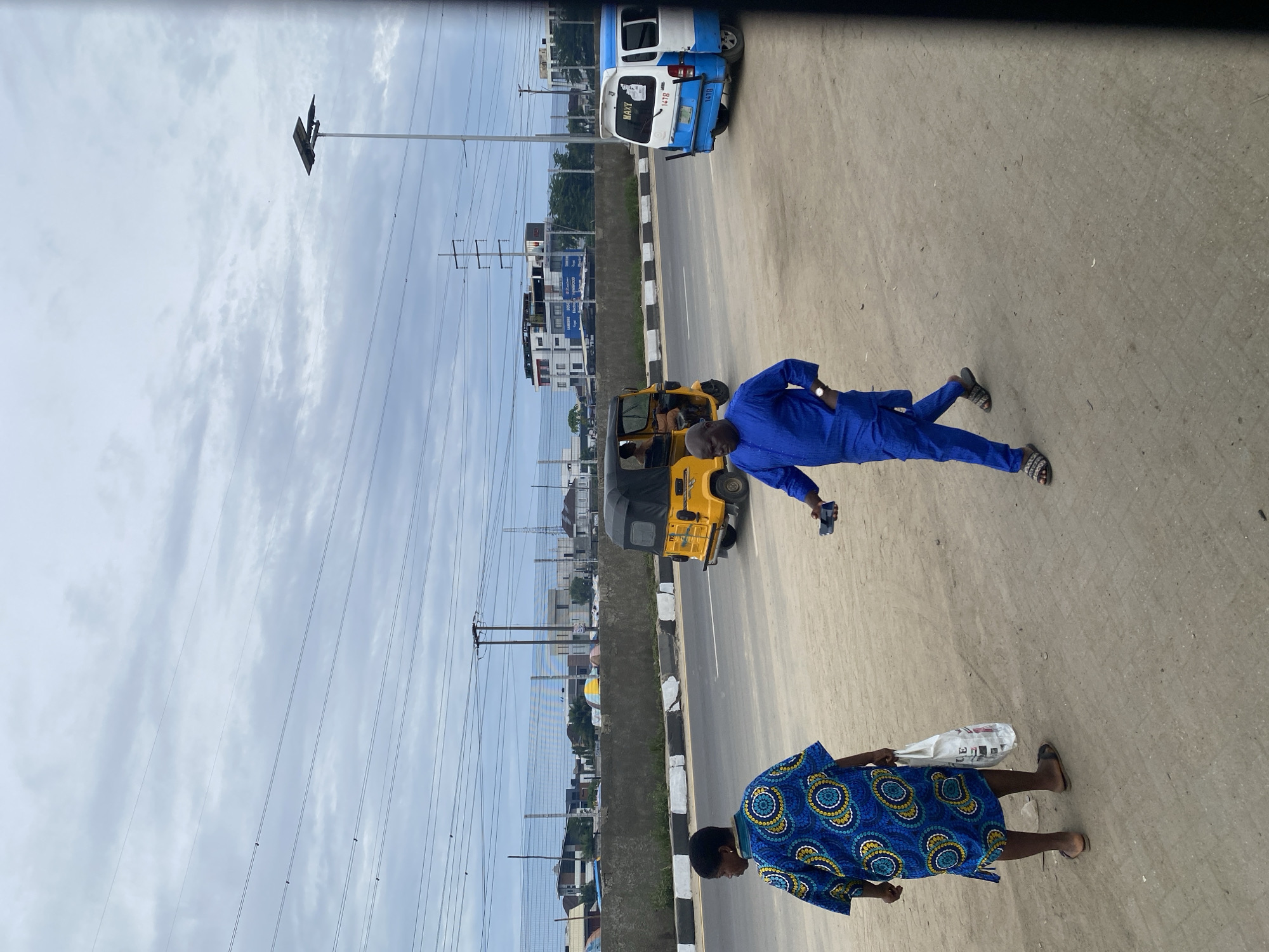 Morning pedestrians walk along Lekki street amid light traffic