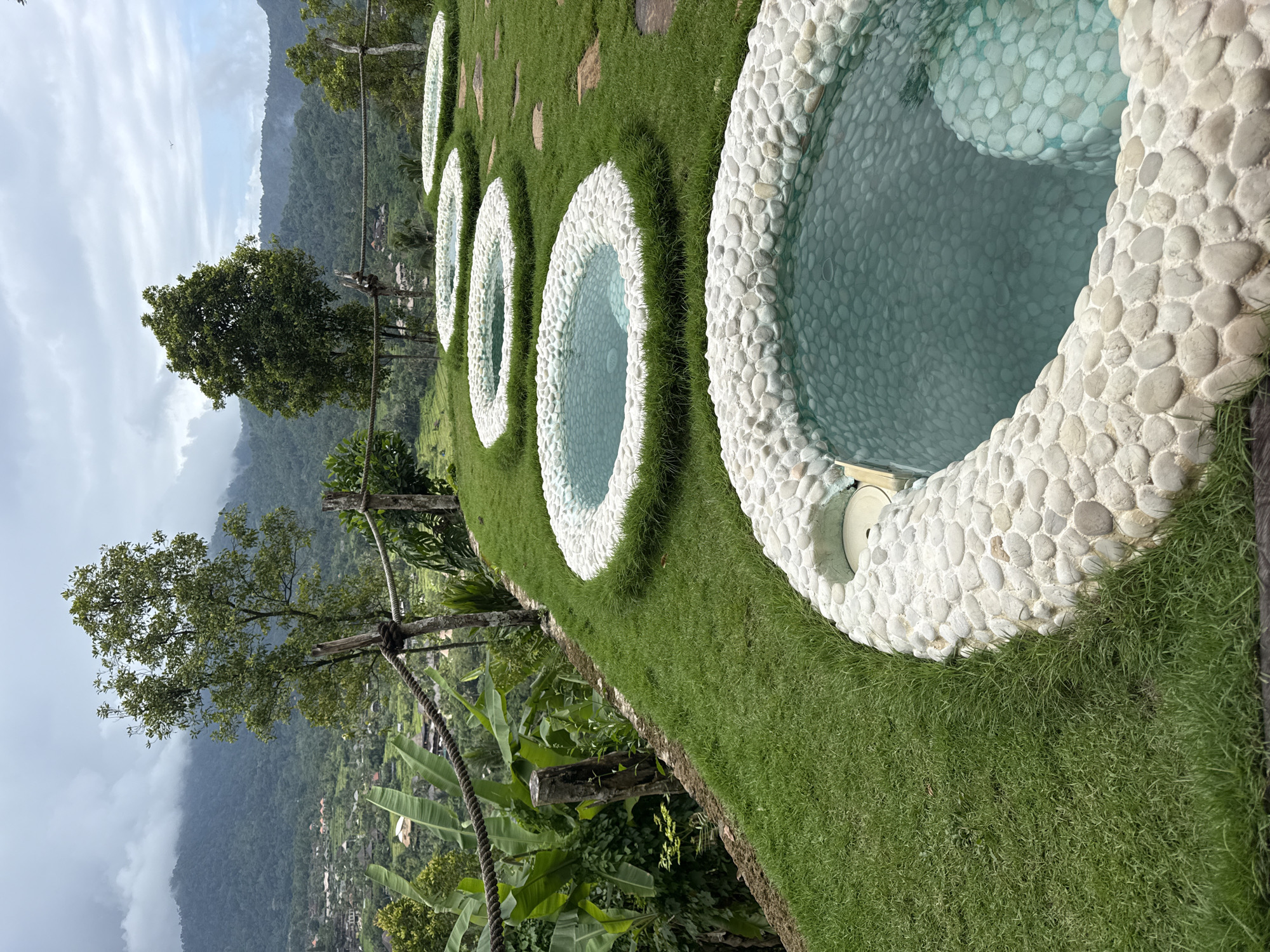 Hen walks between stone pools in Sidemen, Indonesia