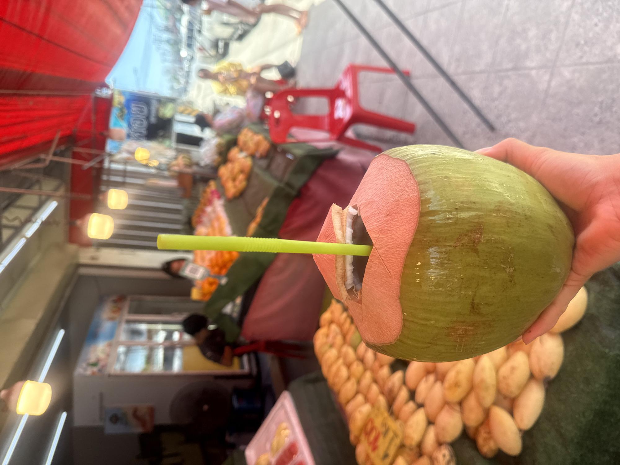 Tropical fruit stall in Ko Samui, coconut in hand