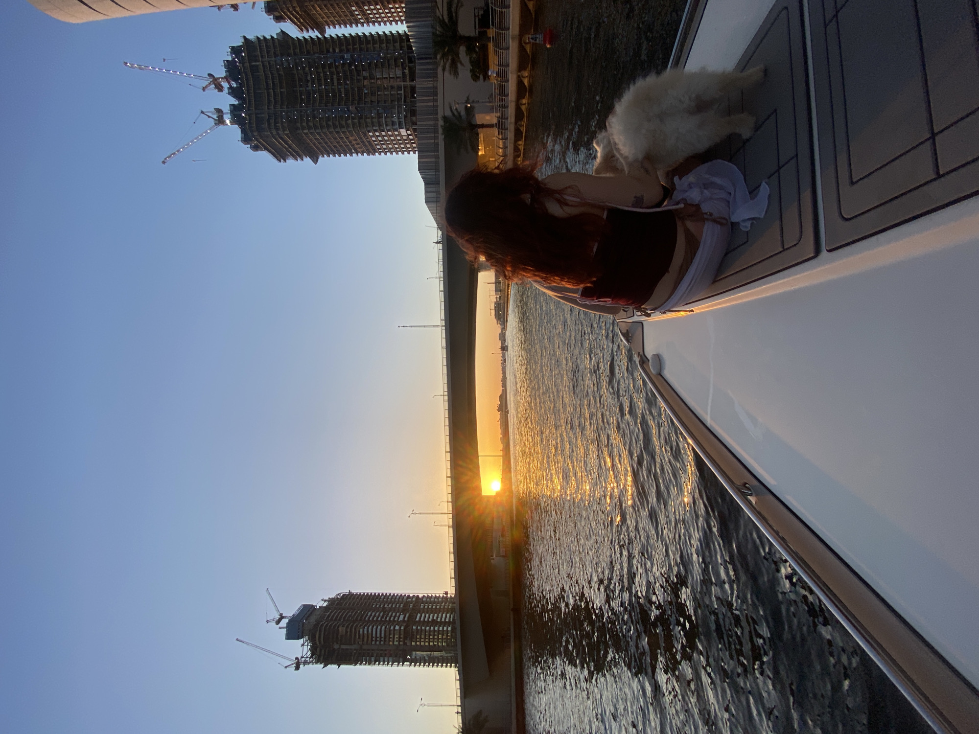 Woman enjoys sunset boat ride with dogs in Dubai