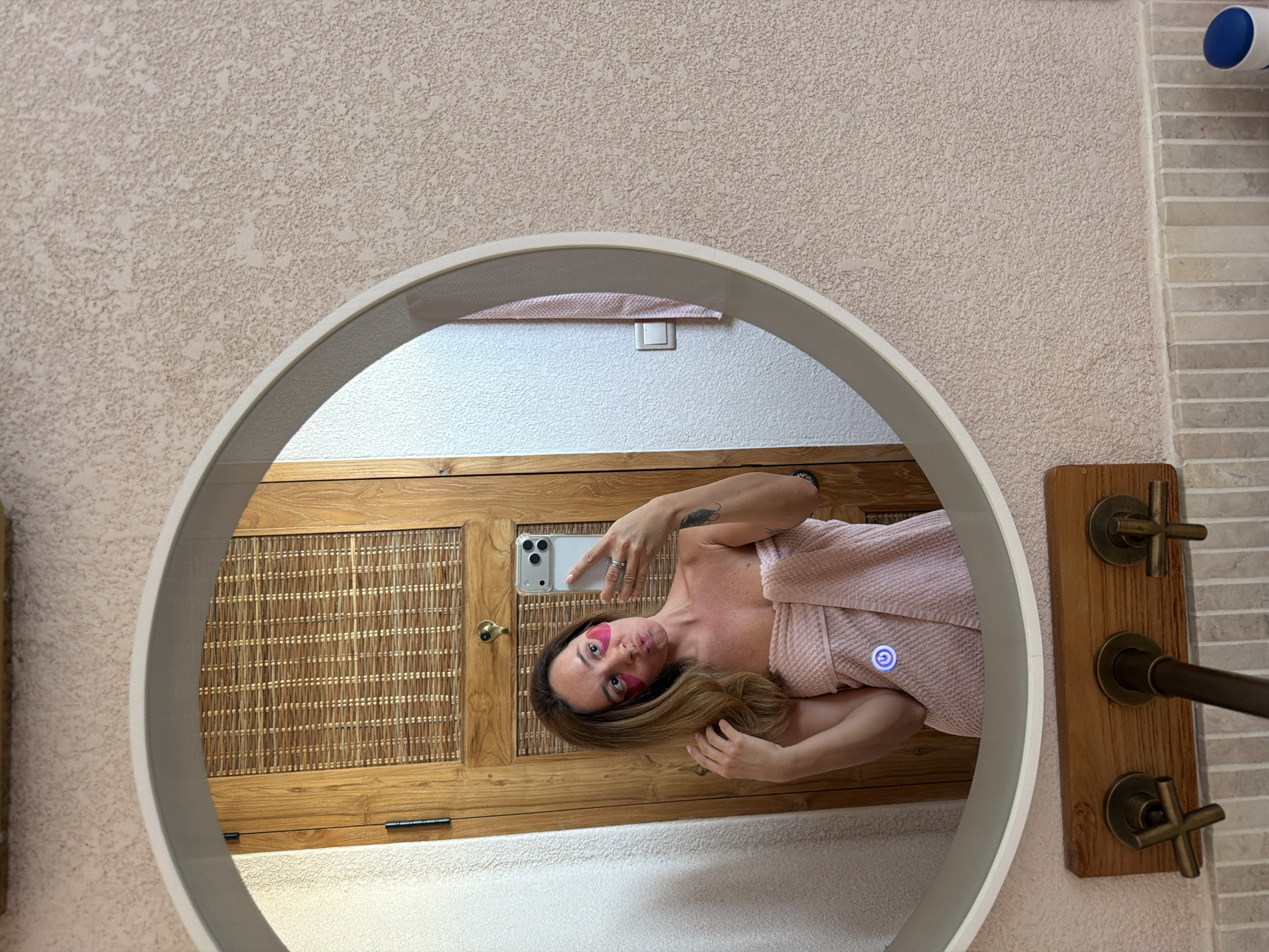 Woman takes morning selfies in Mengwi bathroom wearing pink beauty patches