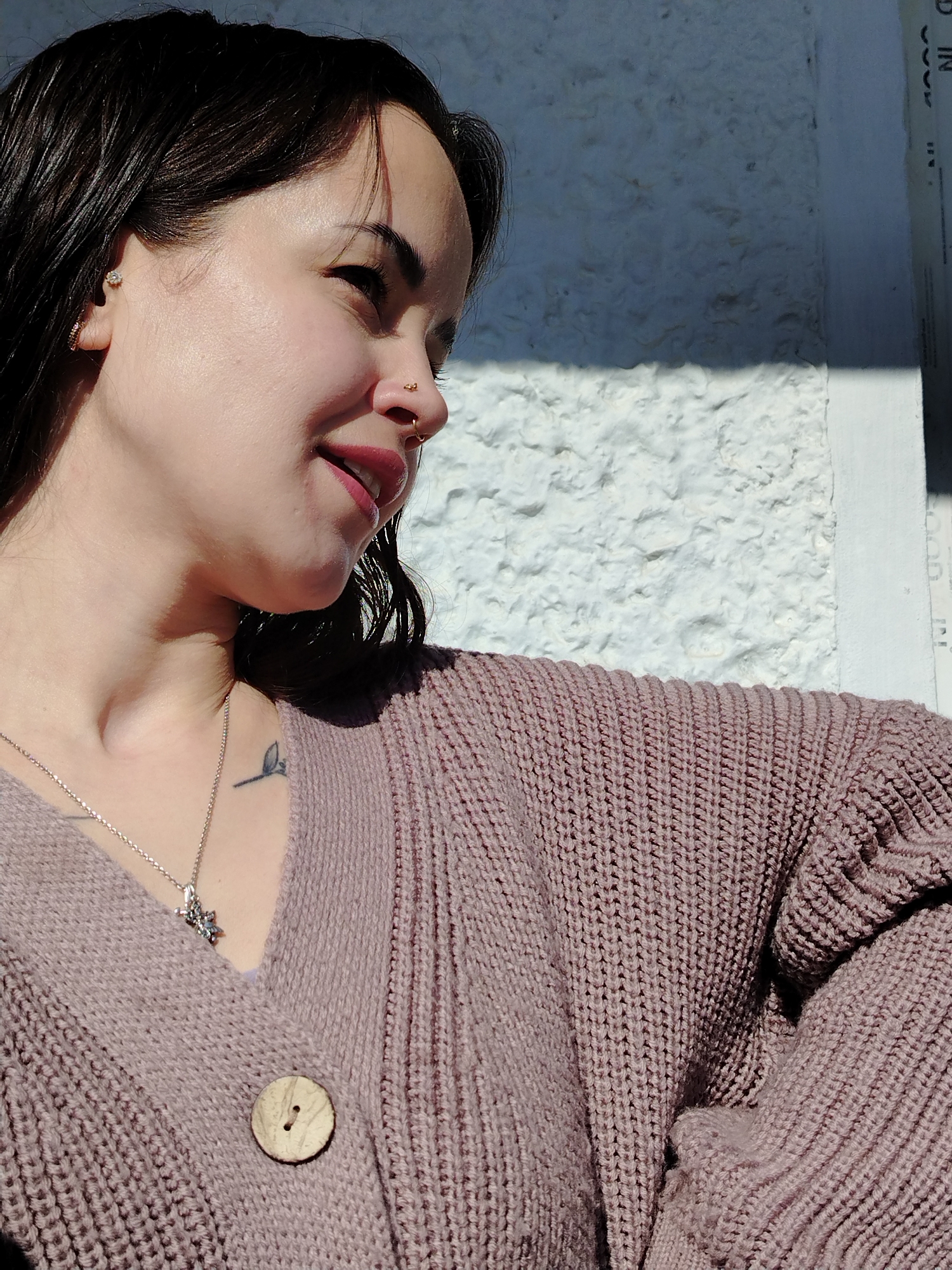 Woman captured smiling in sunlight at undisclosed location