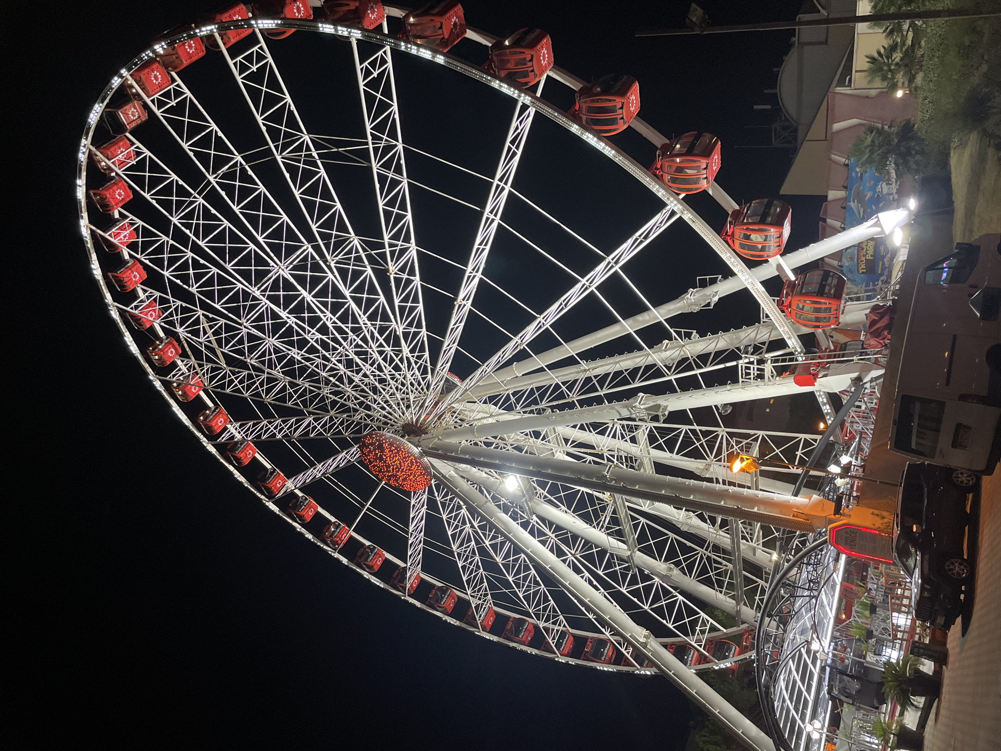 Illuminated Ferris wheel spinning after dark in Jesolo