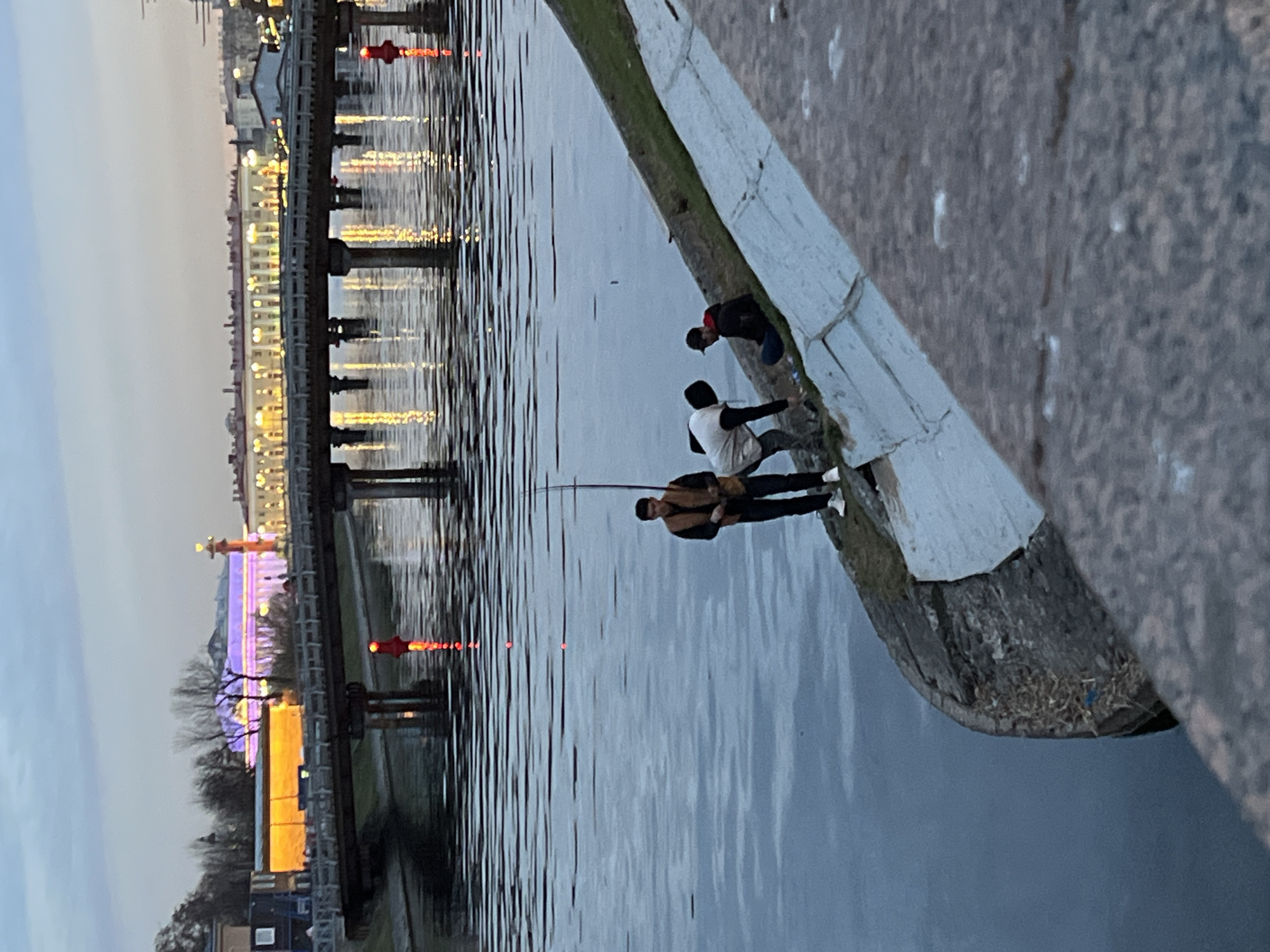 Evening fishing scene captured along Saint Petersburg waterfront at dusk