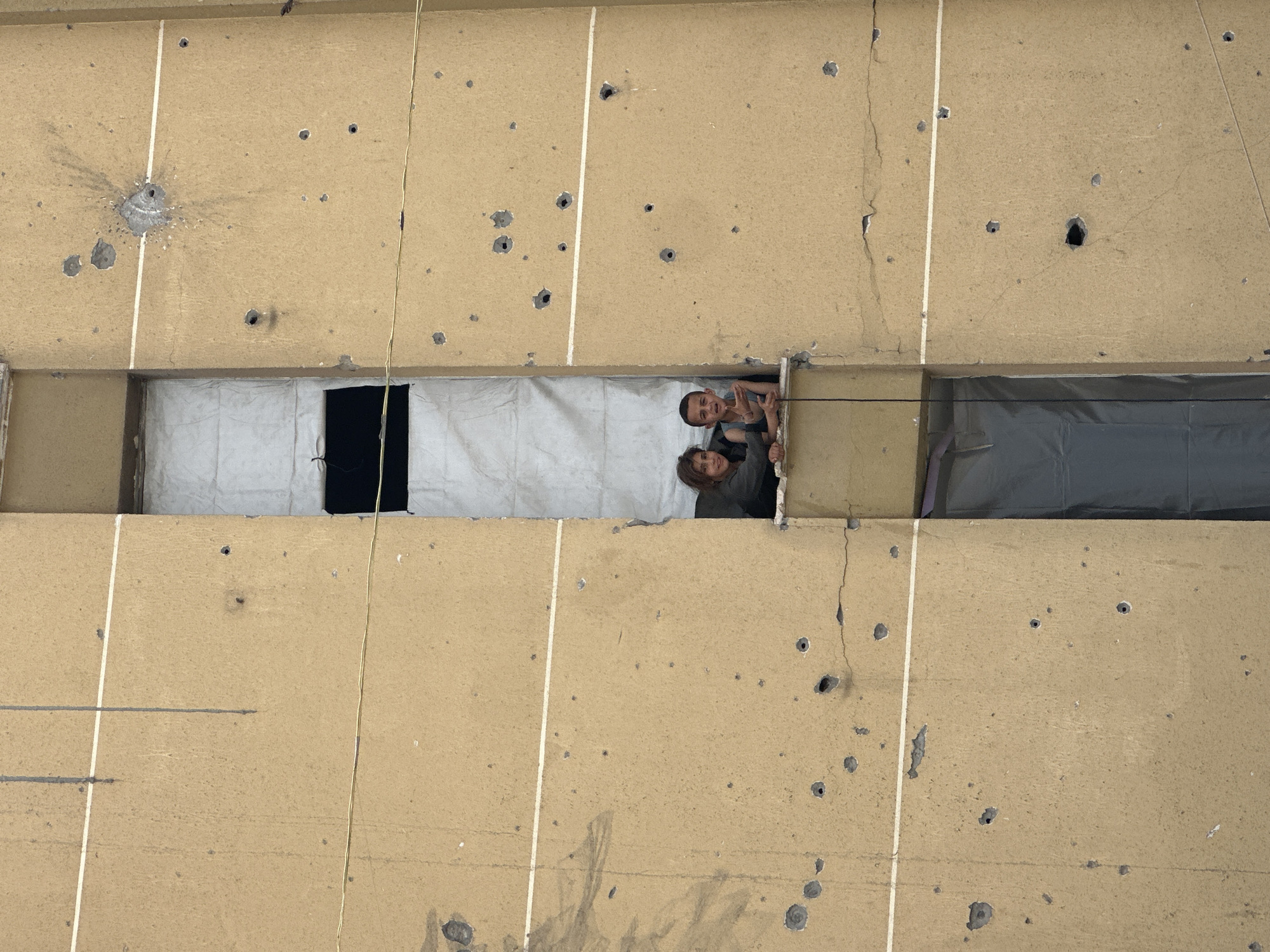 Damaged buildings, displacement camps documented in unknown urban area