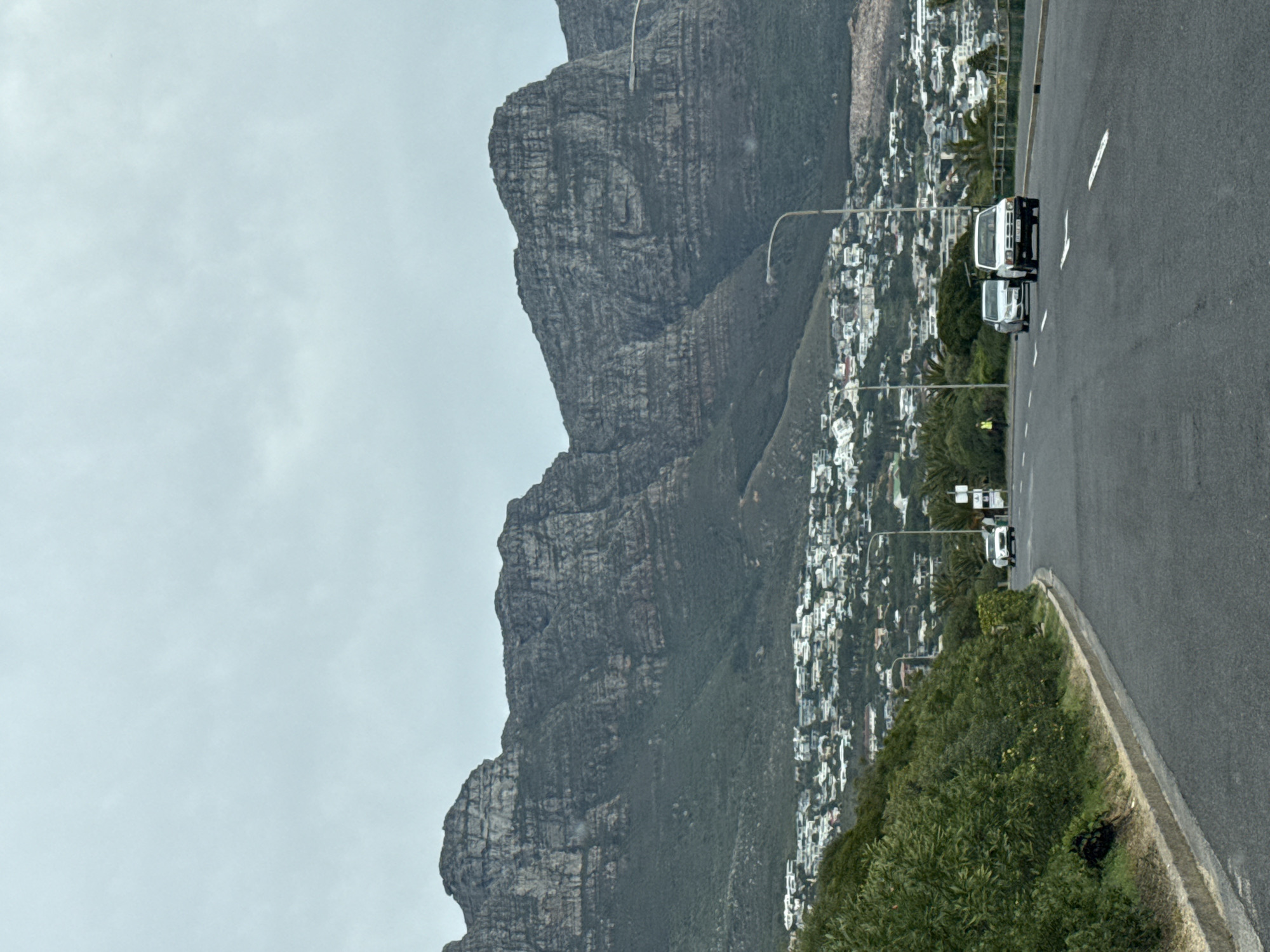 White trucks travel road near Table Mountain, Cape Town