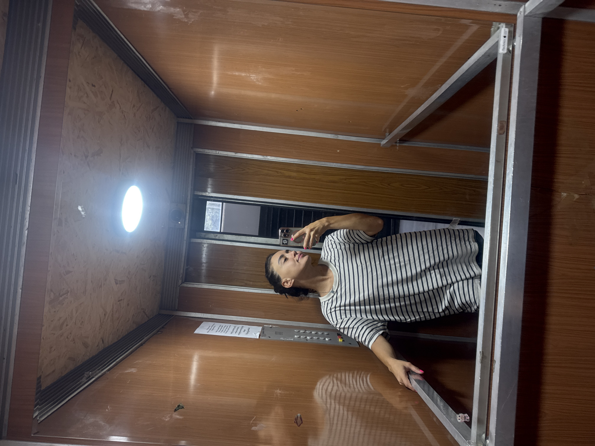Elevator selfie in a wood-paneled lift, Tbilisi
