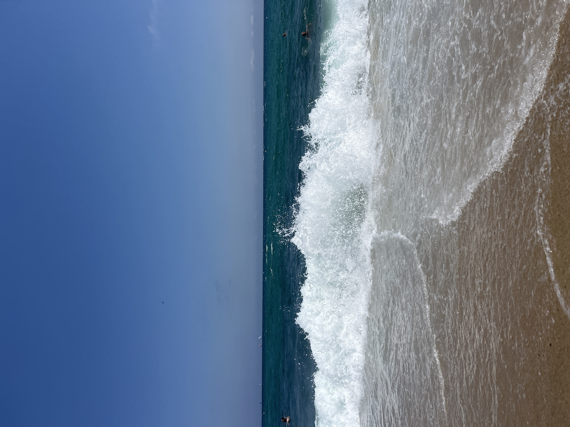 Waves breaking on a Barcelona beach, helicopter passing overhead