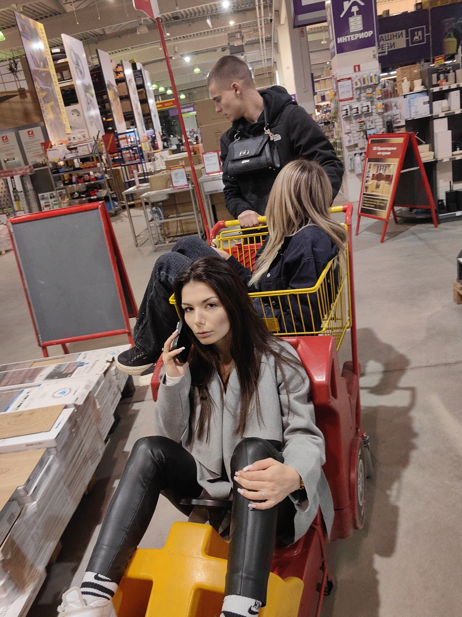 Young people ride shopping carts playfully through Sofia store