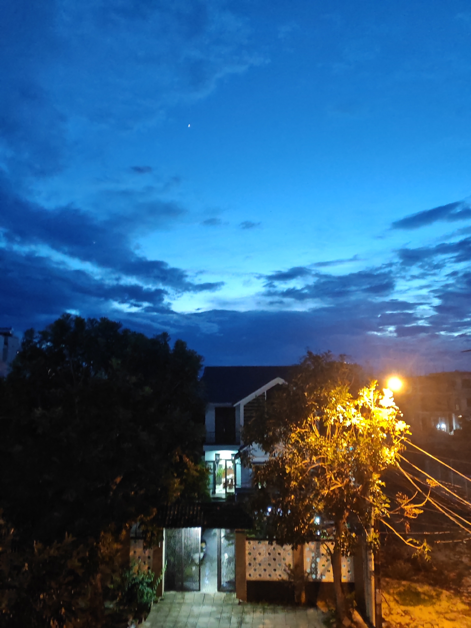 Đà Nẵng streets at dusk, streetlamps on, deep blue sky