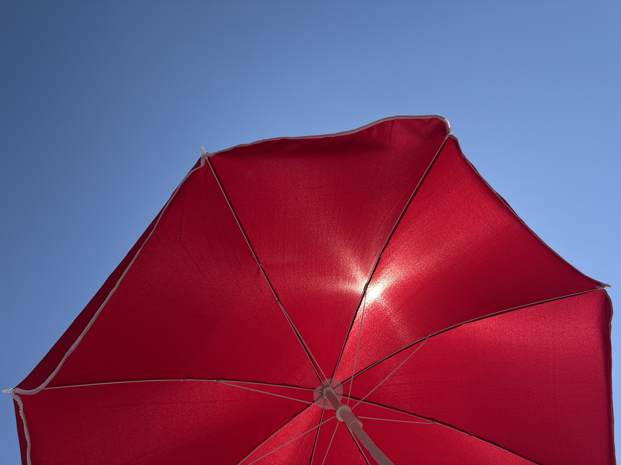 Afternoon at a Montenegro pebble beach, red umbrella and all