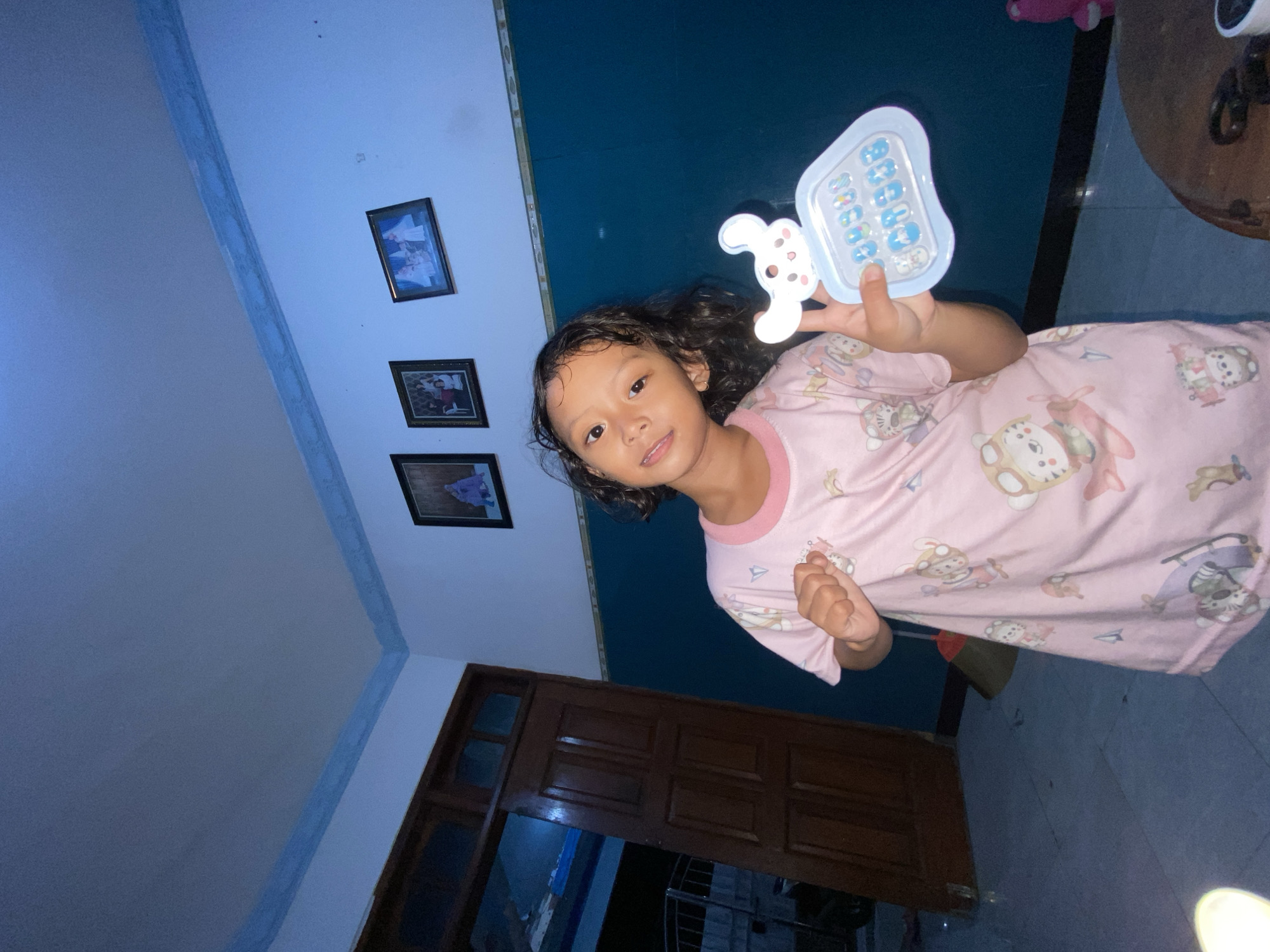 Child plays with toy phone in Indonesian home