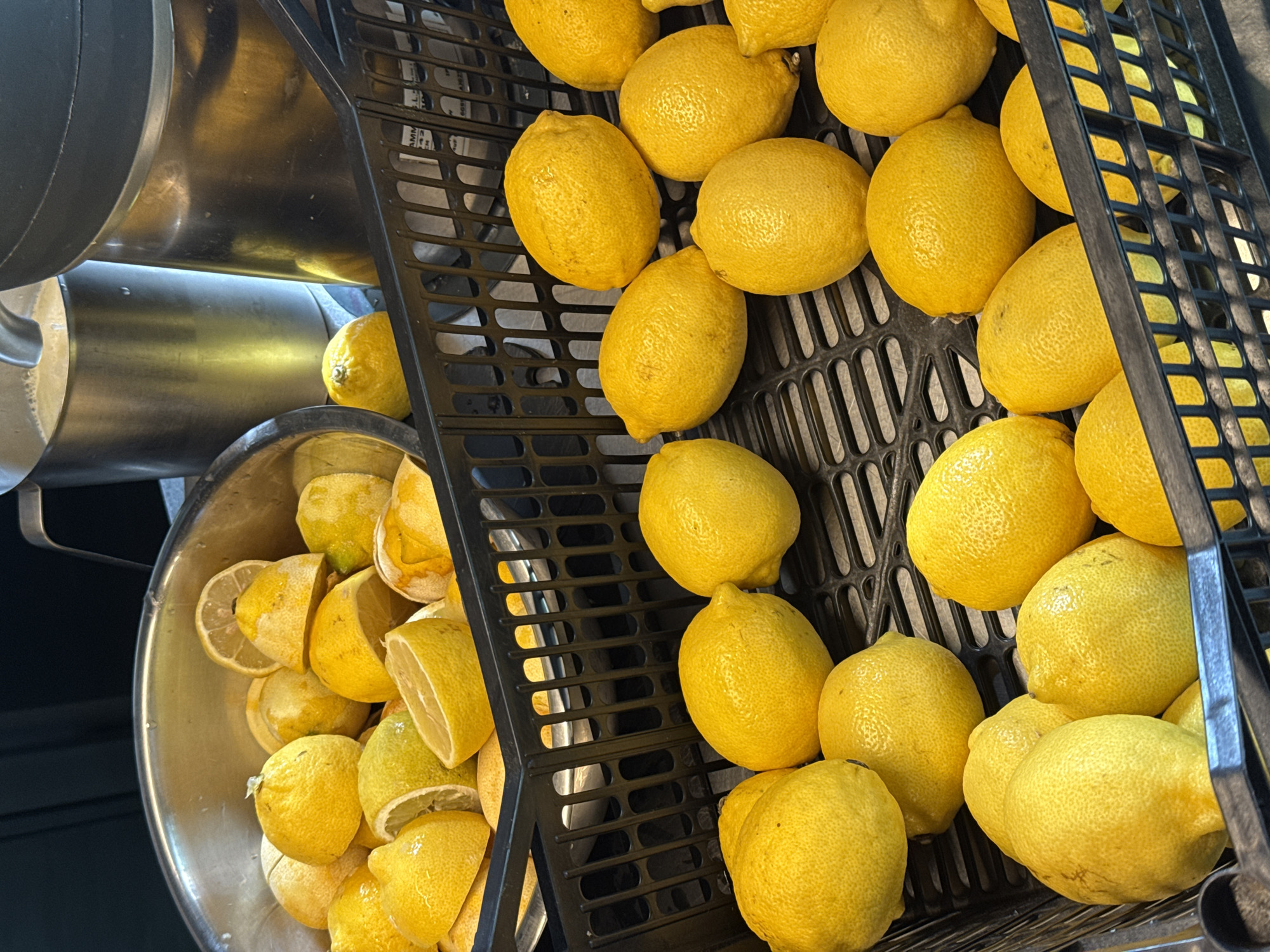 Fresh lemons, whole and halved, in a silver bowl
