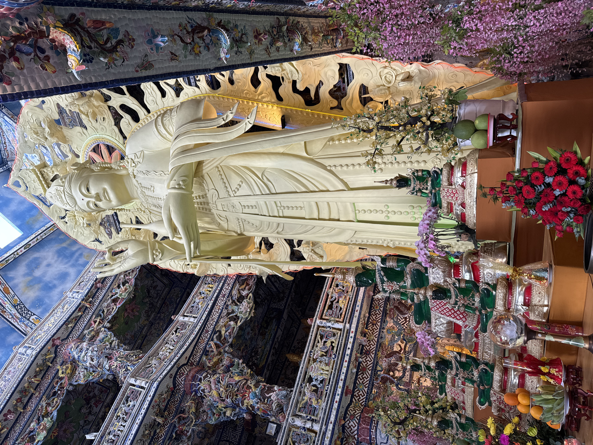 Ornate Buddhist temple complex with gold statues in Xuân Thành