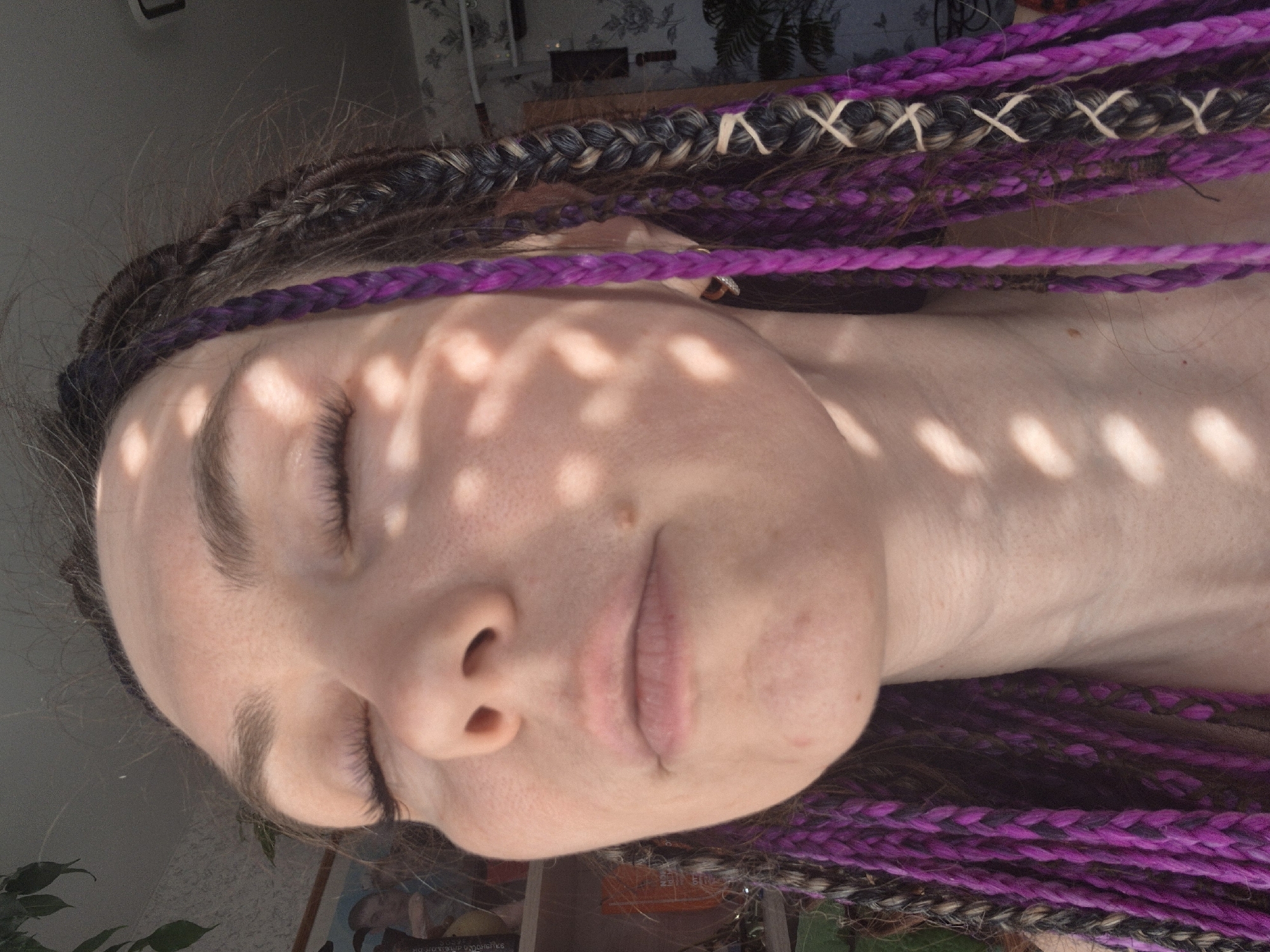 Person rests in dappled sunlight, eyes closed