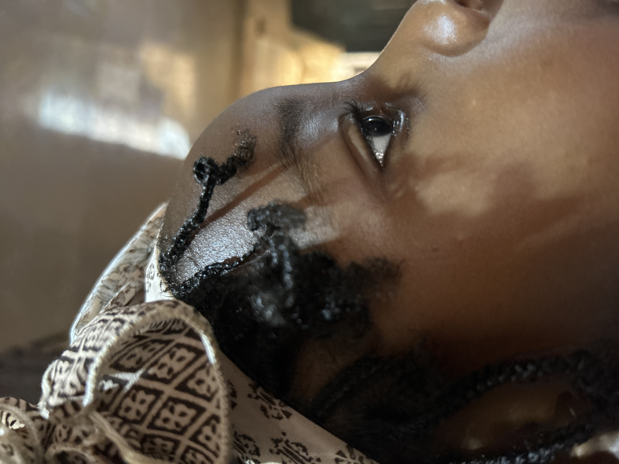 Person with braids resting in Jos, Nigeria morning