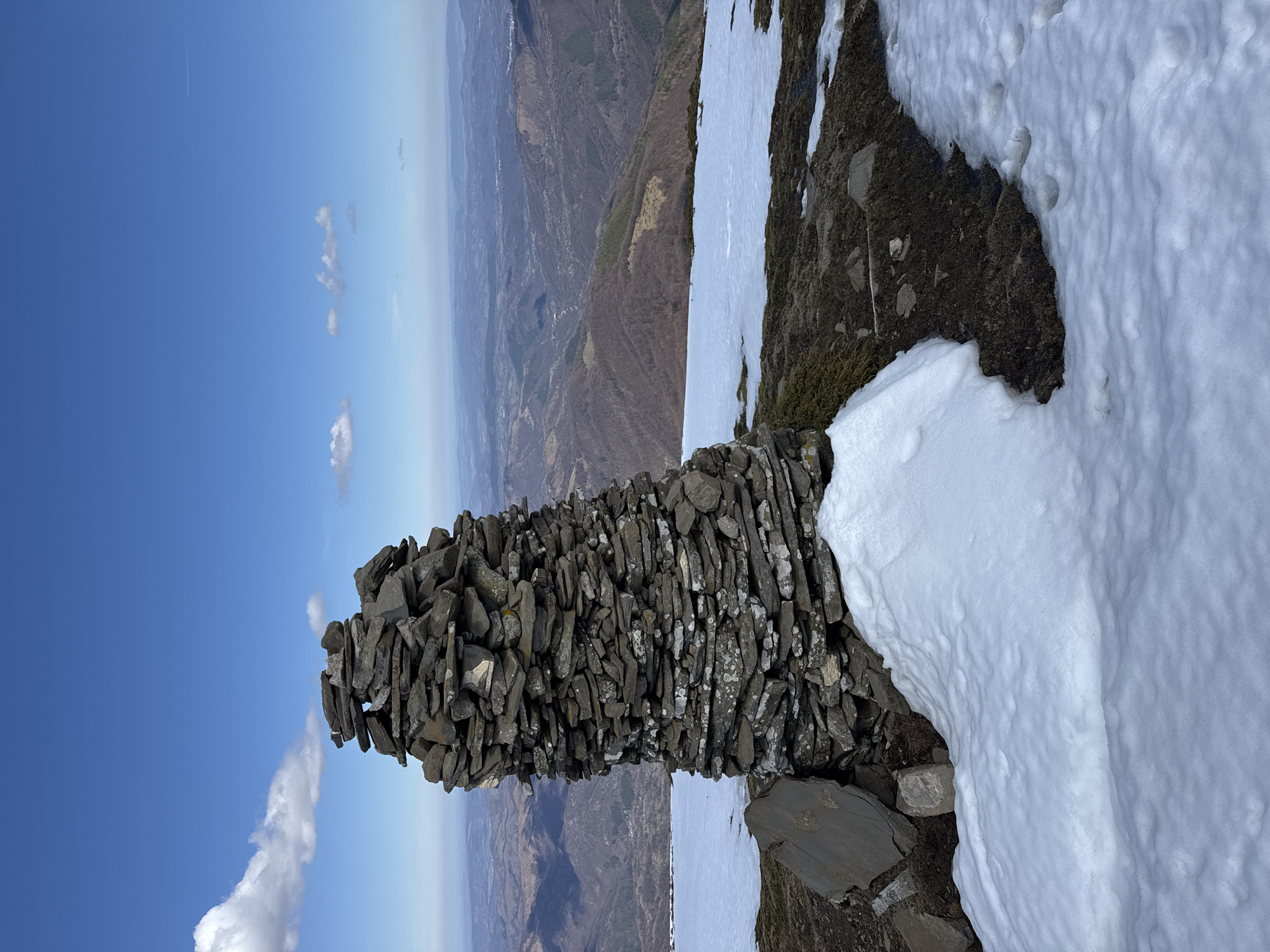 Stone cairn and snowy mountain views documented in Bulgaria