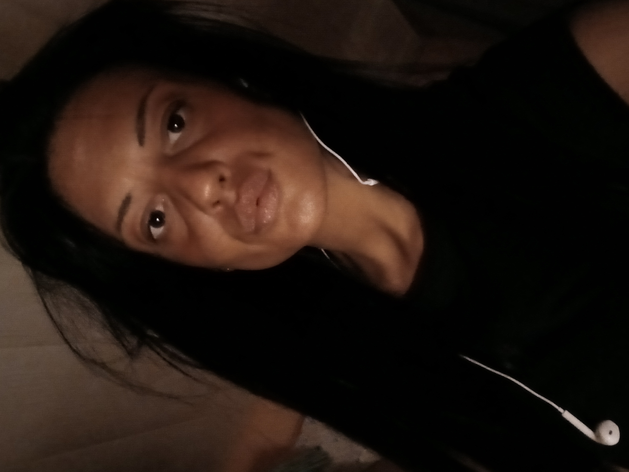 Woman photographs herself indoors with baby bassinet nearby