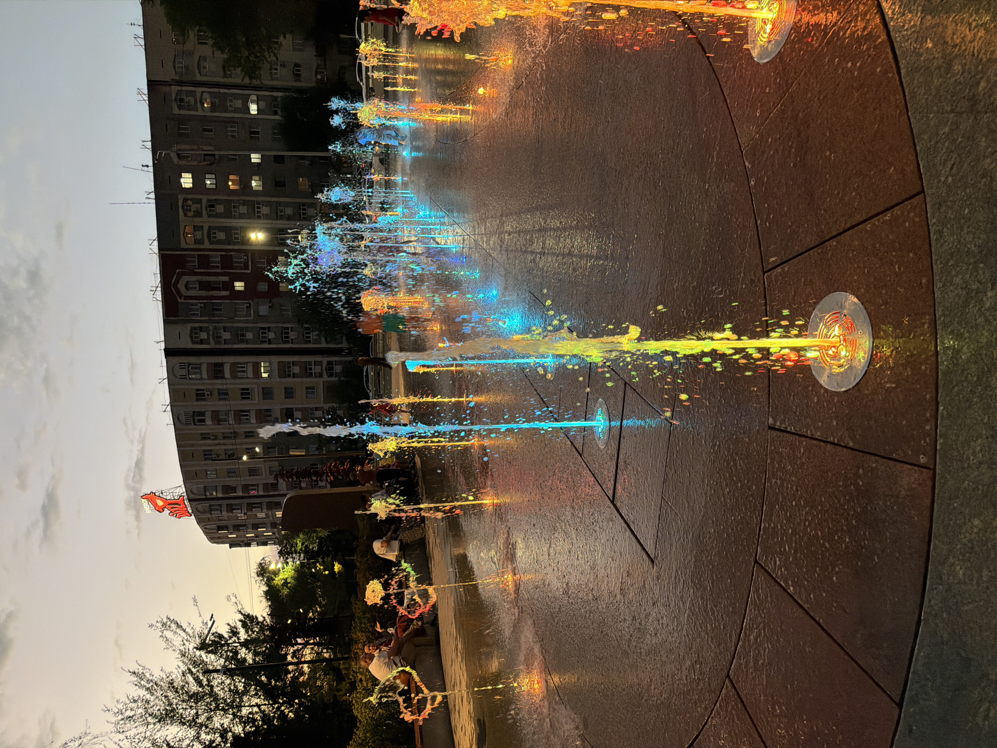 Almaty at dusk: lit fountains and busy highway traffic