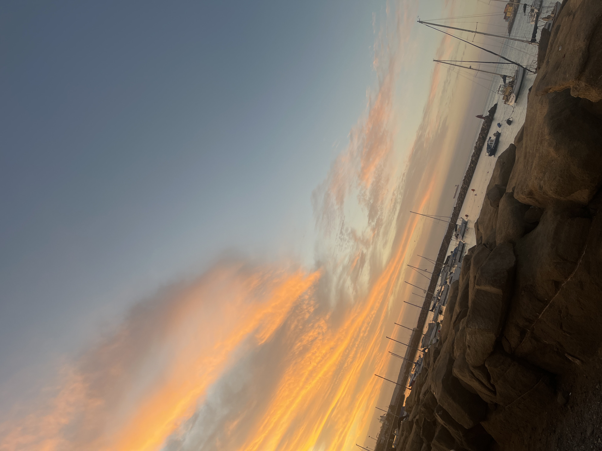 Vibrant sunset illuminates Arica marina with orange clouds
