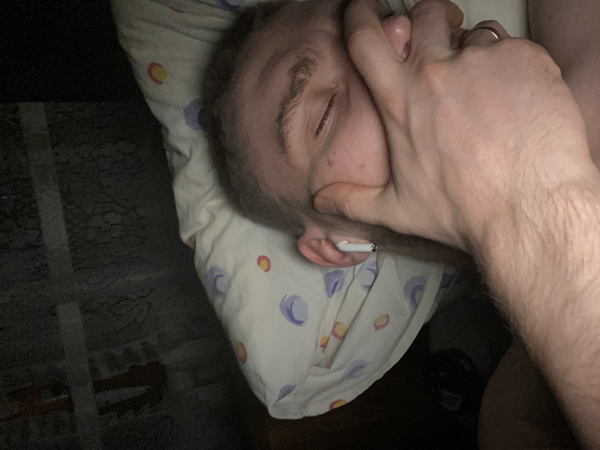 Man rests on bed in dimly lit room in Russia