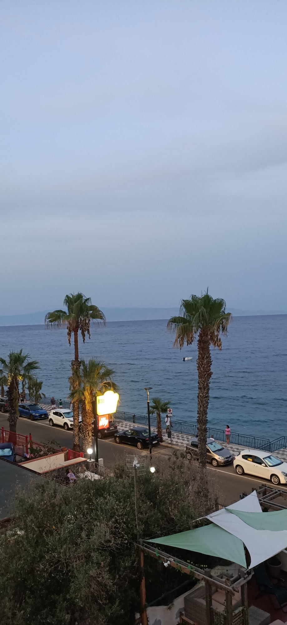 Ancient ruins and calm seas along a Mediterranean coast at dusk